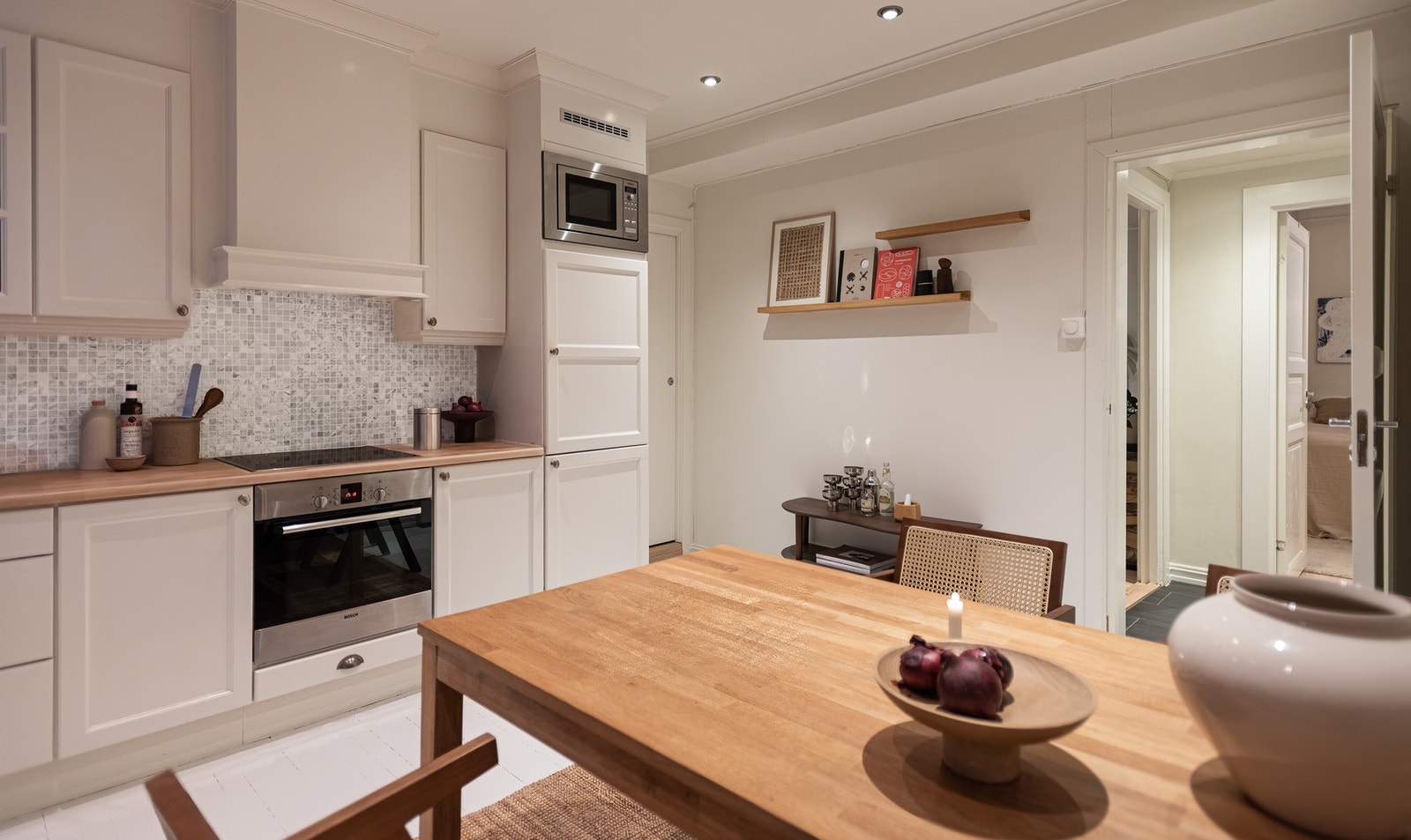 Ventilator over koketopp, nedfelt oppvaskkum og dekorative fliser over benk. Galleribilde