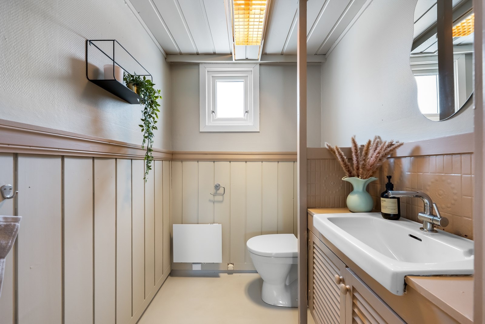 Toalettrommet har tapet og panel på vegger, samt belegg på gulv og naturlig avtrekk. Galleribilde