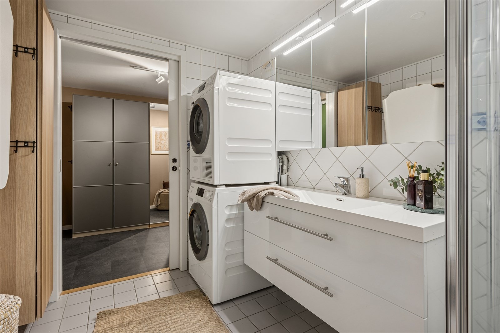 Baderomsinnredningen består av servant med skuffeseksjon, speilskap med overlys, klosett, dusjhjørne med foldedør og opplegg for vaskemaskin. Galleribilde