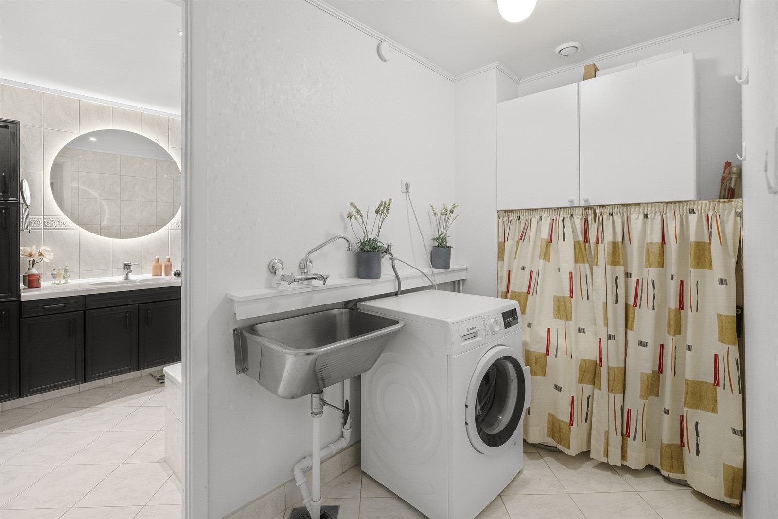 Leiligheten har et praktisk vaskerom som man kommer til før man går videre inn til det helflislagte baderommet. Galleribilde