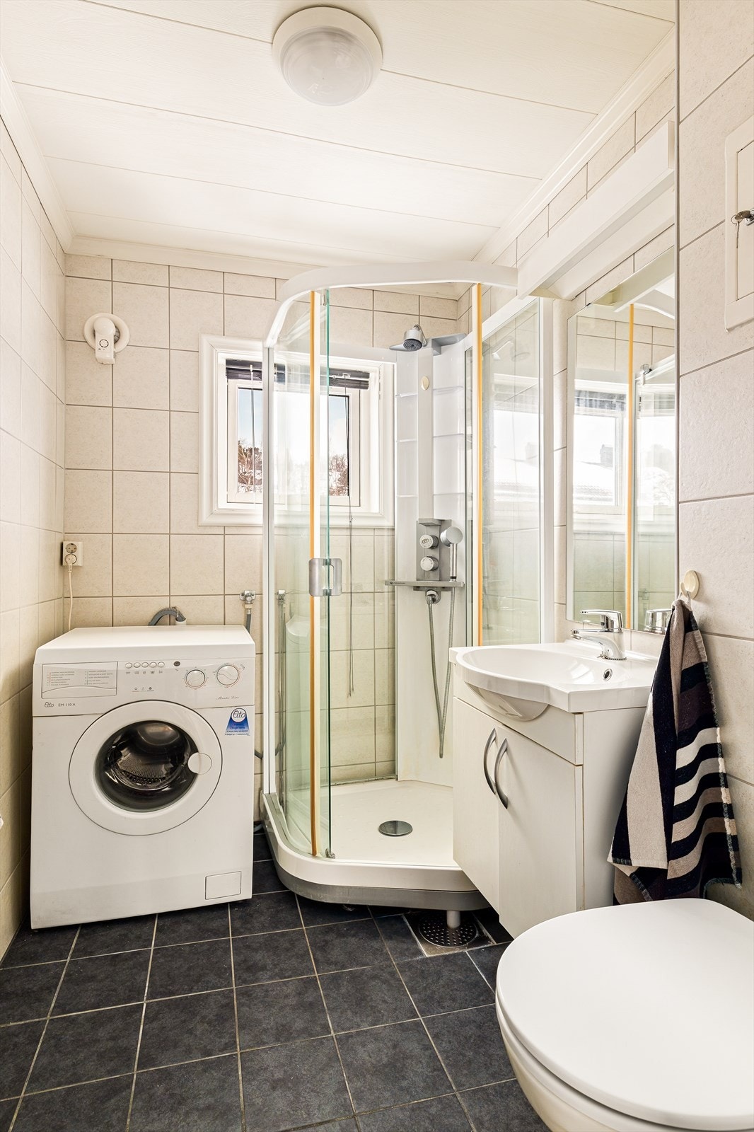 Rommet har innredning med nedfelt servant, veggmontert toalett, dusjkabinett og opplegg for vaskemaskin. Det er elektrisk styrt vifte. Tilluft via spalte ved dørterskel og ventil i vindu. Galleribilde