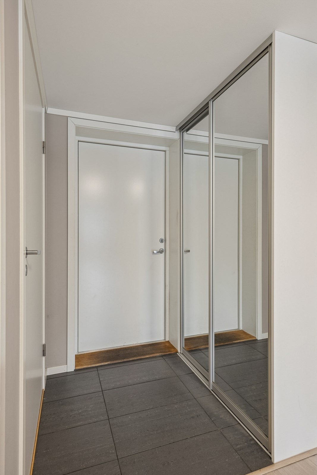 Flislagt gulv og praktisk skyvedørsgarderobe i entrèen. Galleribilde