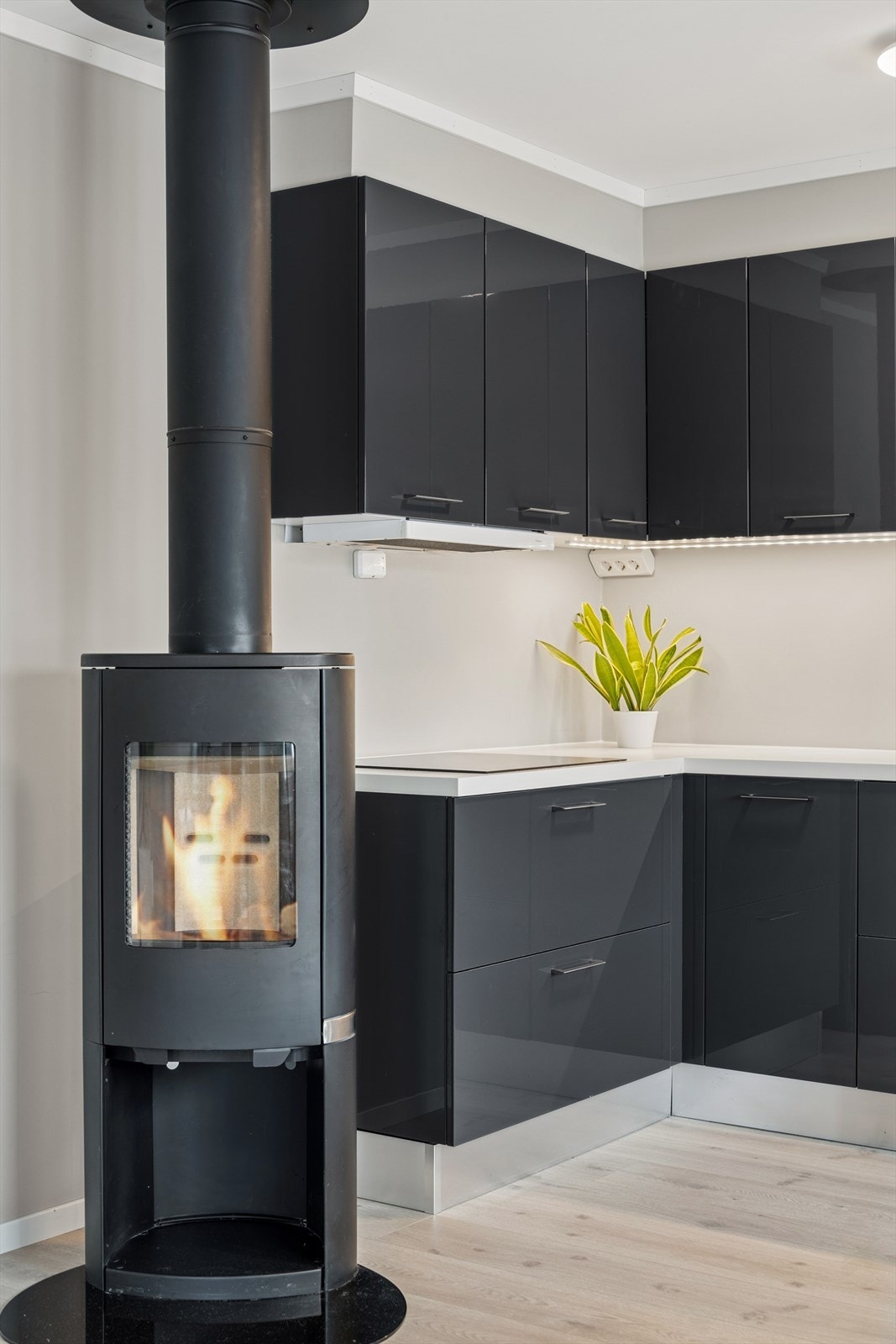 Med fyr i peisovnen som er montert i rommet, tilføres den lune, gode varmen. Galleribilde