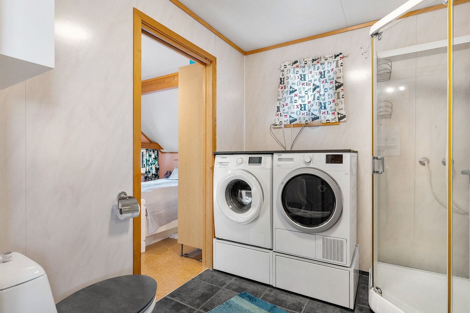 Bad i hovedetasjen har kjeramiske fliser på gulv og baderomsplater på vegger. Galleribilde