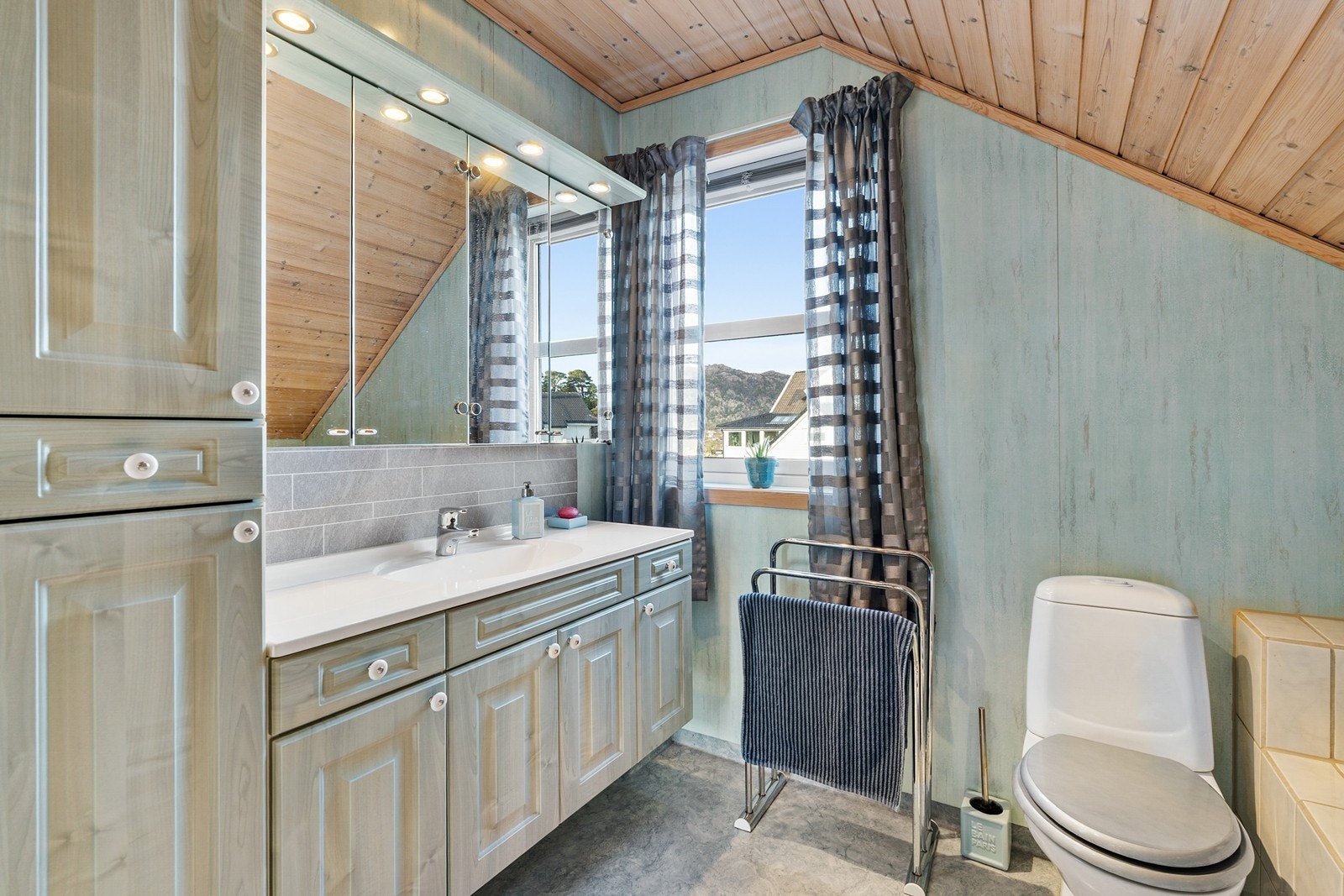 Bad i 2. etasjen har vinylbelegg på gulv og vegger med baderomsplater. Det er flislagt rundt badekar. Galleribilde