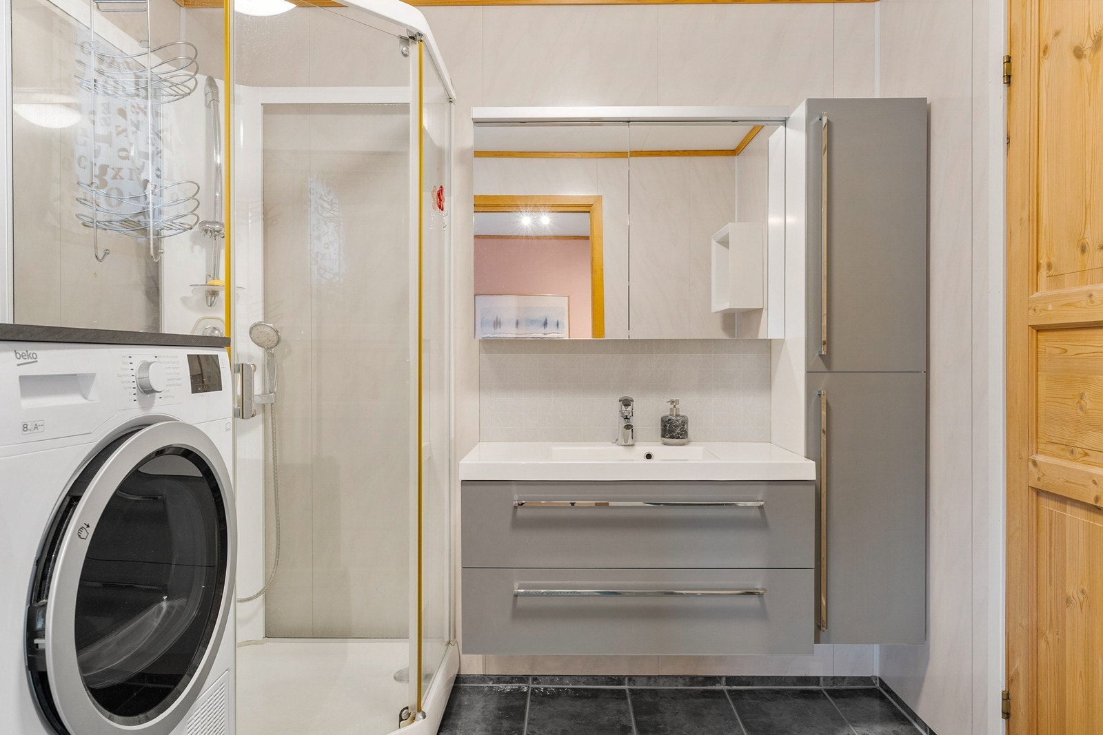 Badet er innredet med servant i baderomsmøbel, toalett og dusjkabinett. Det er opplegg for oppvaskmaskin. Galleribilde