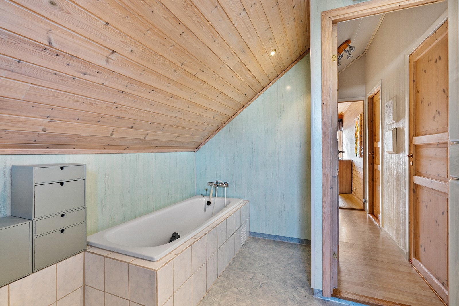 Badet er innredet med servant i baderomsmøbel, toalett og badekar. Galleribilde