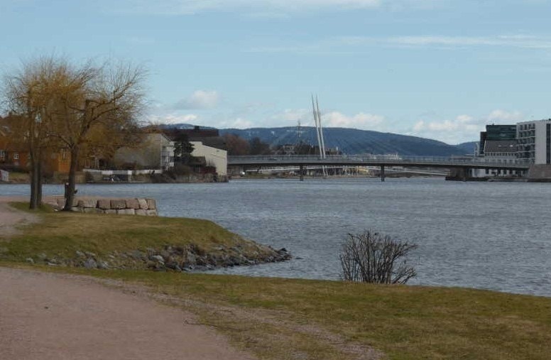 Kort fottur fra leiligheten, finnes Hovet Strand og turstien langs elvepromenaden retning Drammen Sentrum. Øvre Sund bru og Ypsilon bakgrunnen Galleribilde
