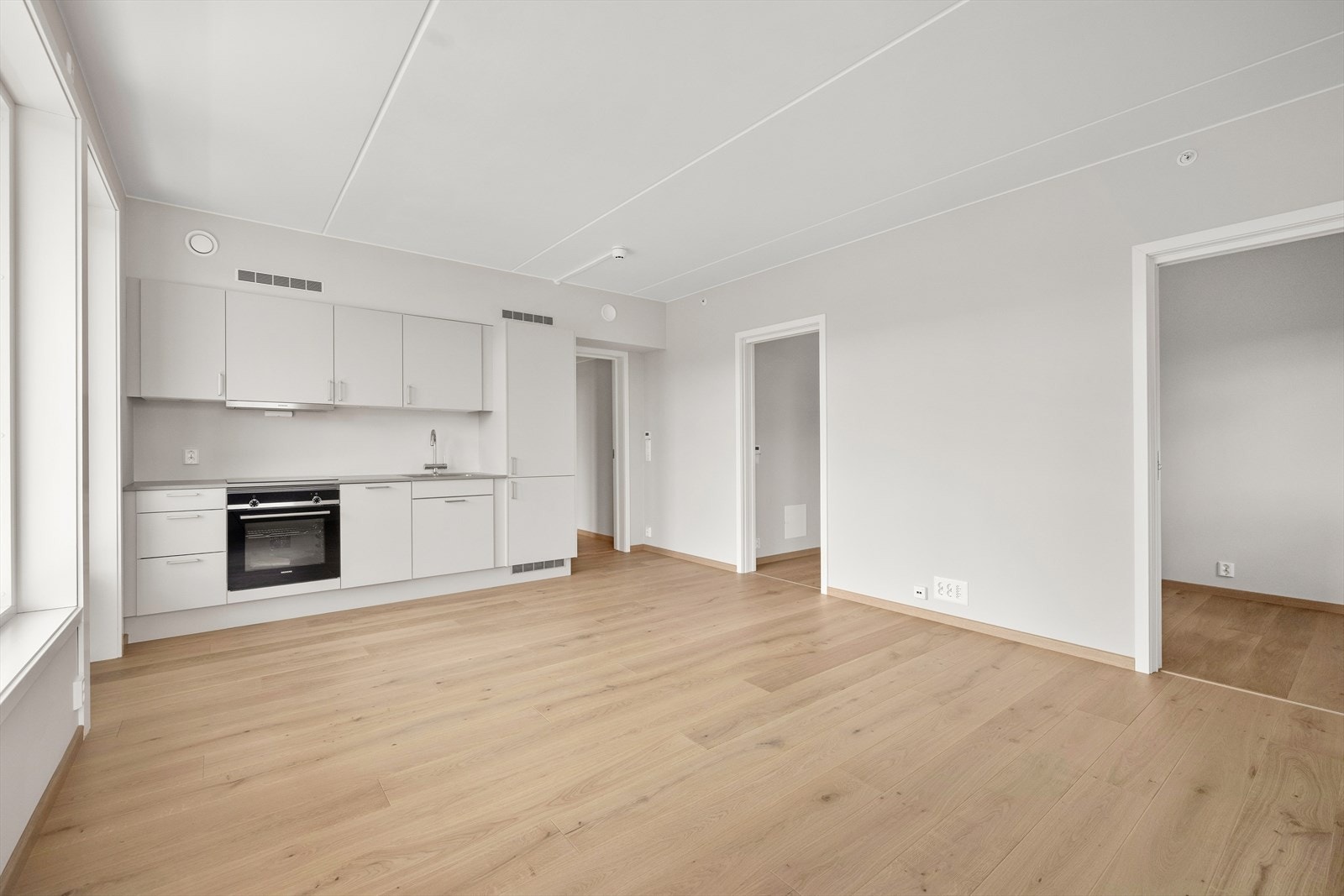 Det er demping på alle skuffer og skapdører, og under oppvaskkum er det skuff med avfallsbeholdere. LED-downlights med dimmer og stikkontakt i underkant av overskap. Galleribilde