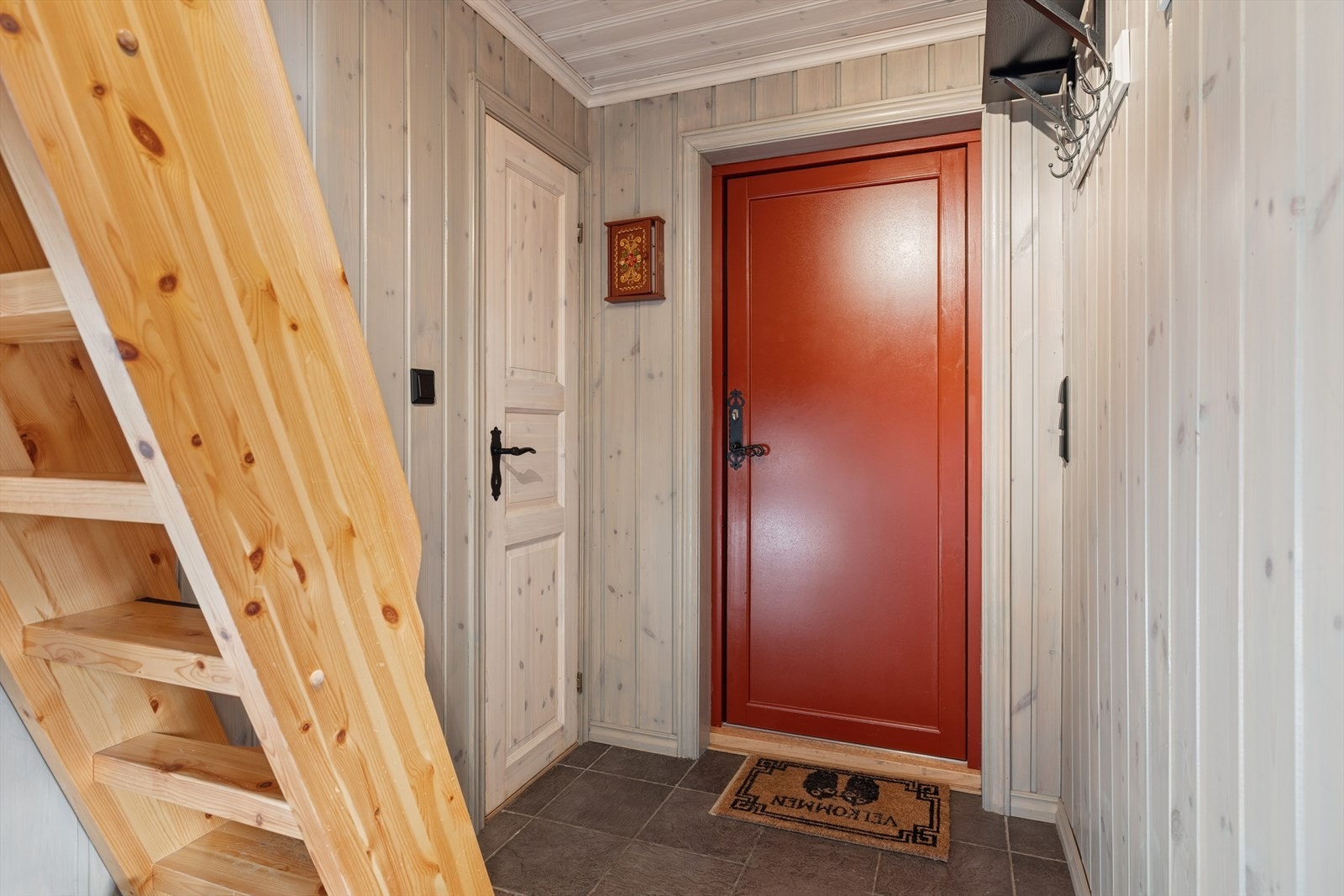 Romslig gang med plass til å henge fra seg - og badet ligger rett innenfor, slik at det er enkelt å holde gangen fri for sko og yttertøy. Trapp fra gang og opp til hemsetasje. Galleribilde