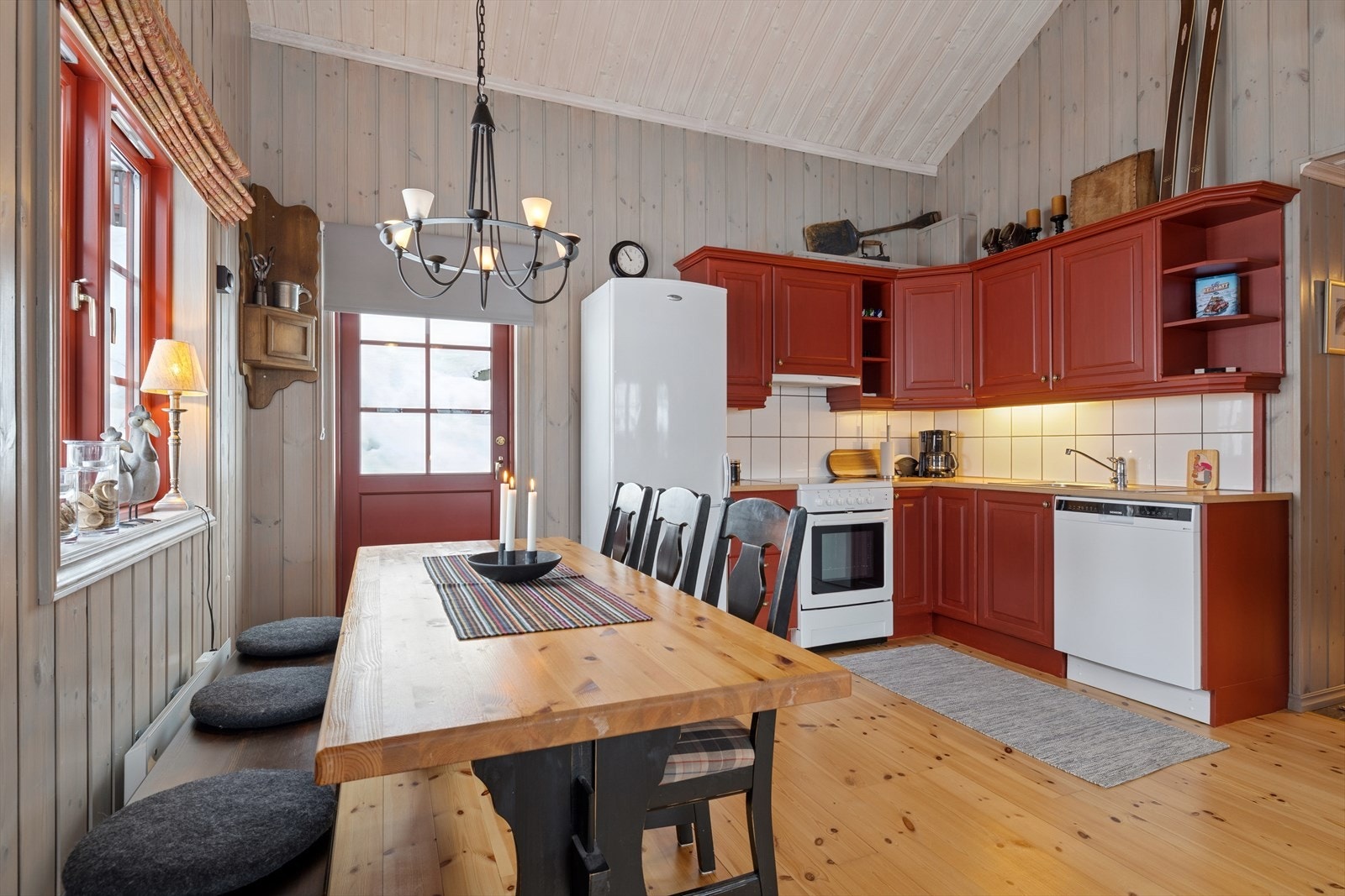 L-formet kjøkken, praktisk plassert i den åpne løsningen mot stuen - med god skapplass og stilren Rørosrød-innredning. Galleribilde