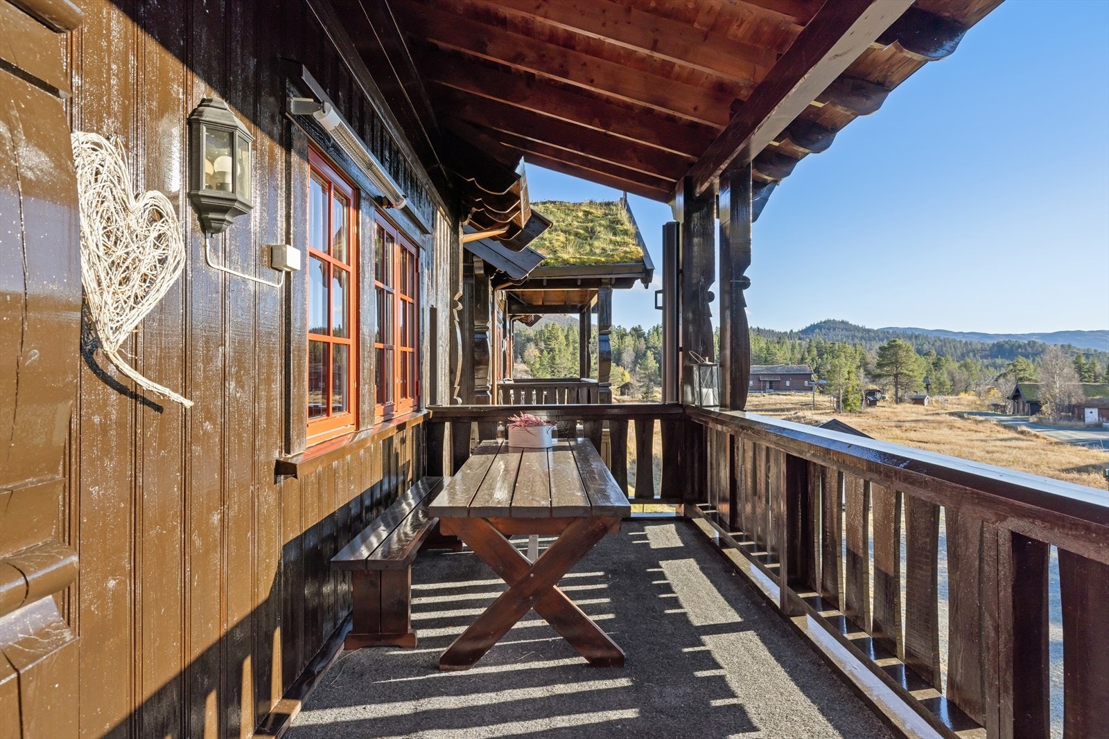 Solrik utsikt rett mot alpinbakken - med vindskjerming og overbygg som gir både ly og lunhet Galleribilde