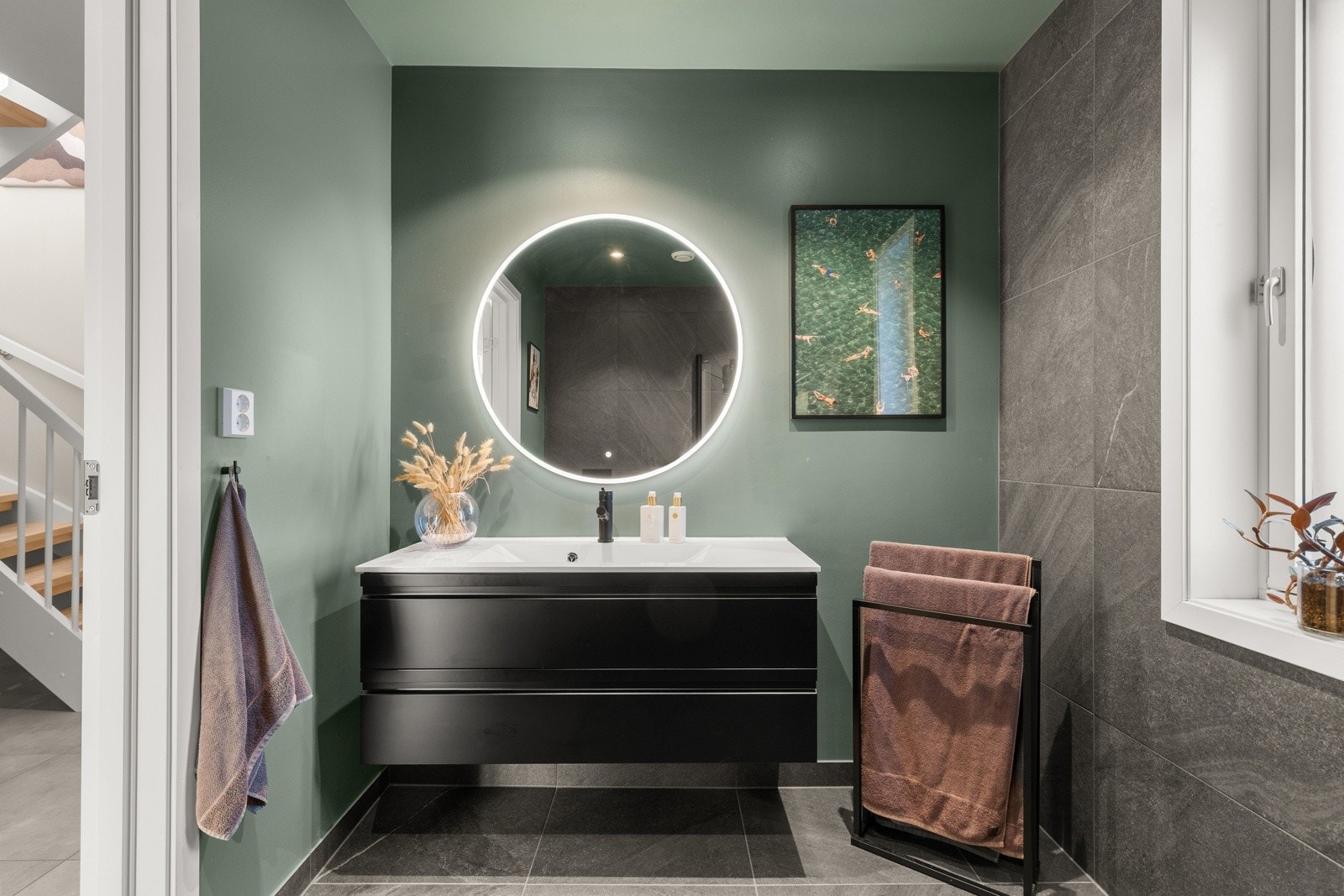 Badet er delikat utformet med en kombinasjon av fliser og malte flater som skaper en harmonisk og moderne atmosfære. Galleribilde