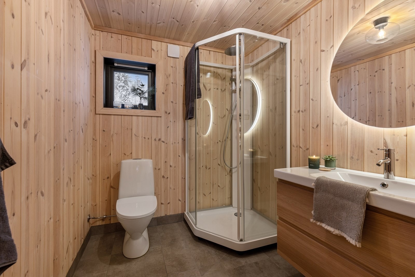 Badet har vegger og himling av panel og flislagt gulv med varmekabler. Galleribilde