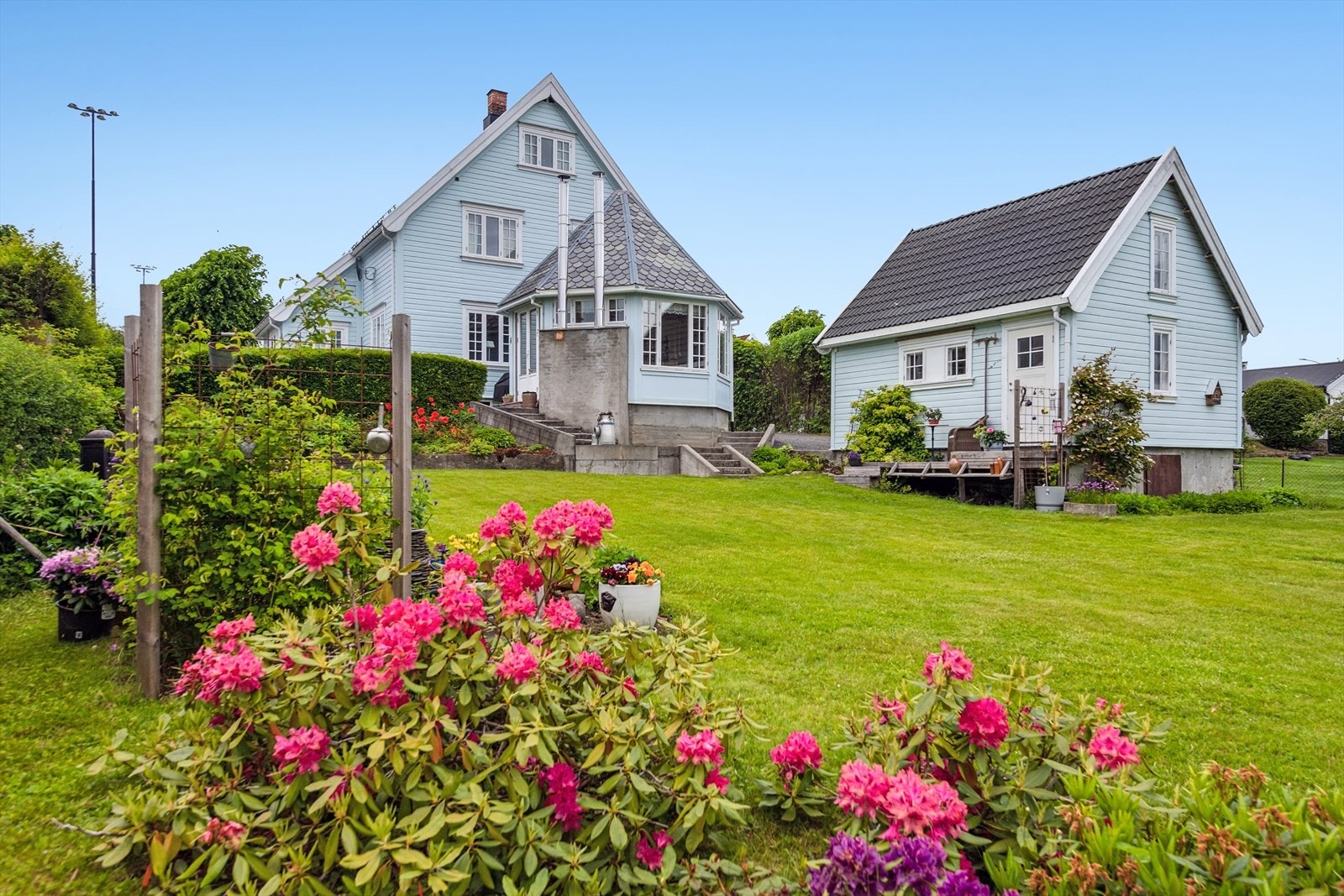 En innholdsrik eiendom med enebolig, dobbelgarasje og en stor, frodig hage. Galleribilde