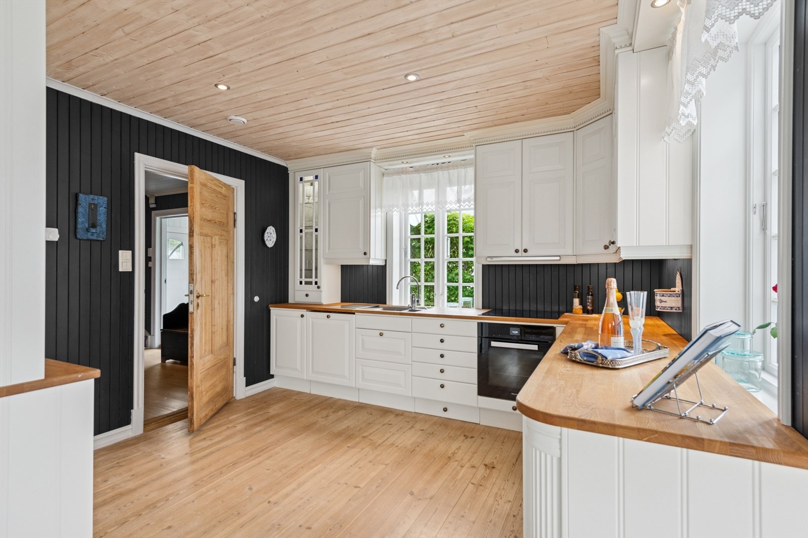 Kjøkkeninnredningen har profilerte fronter og integrerte hvitevarer som stekeovn og koketopp. Galleribilde