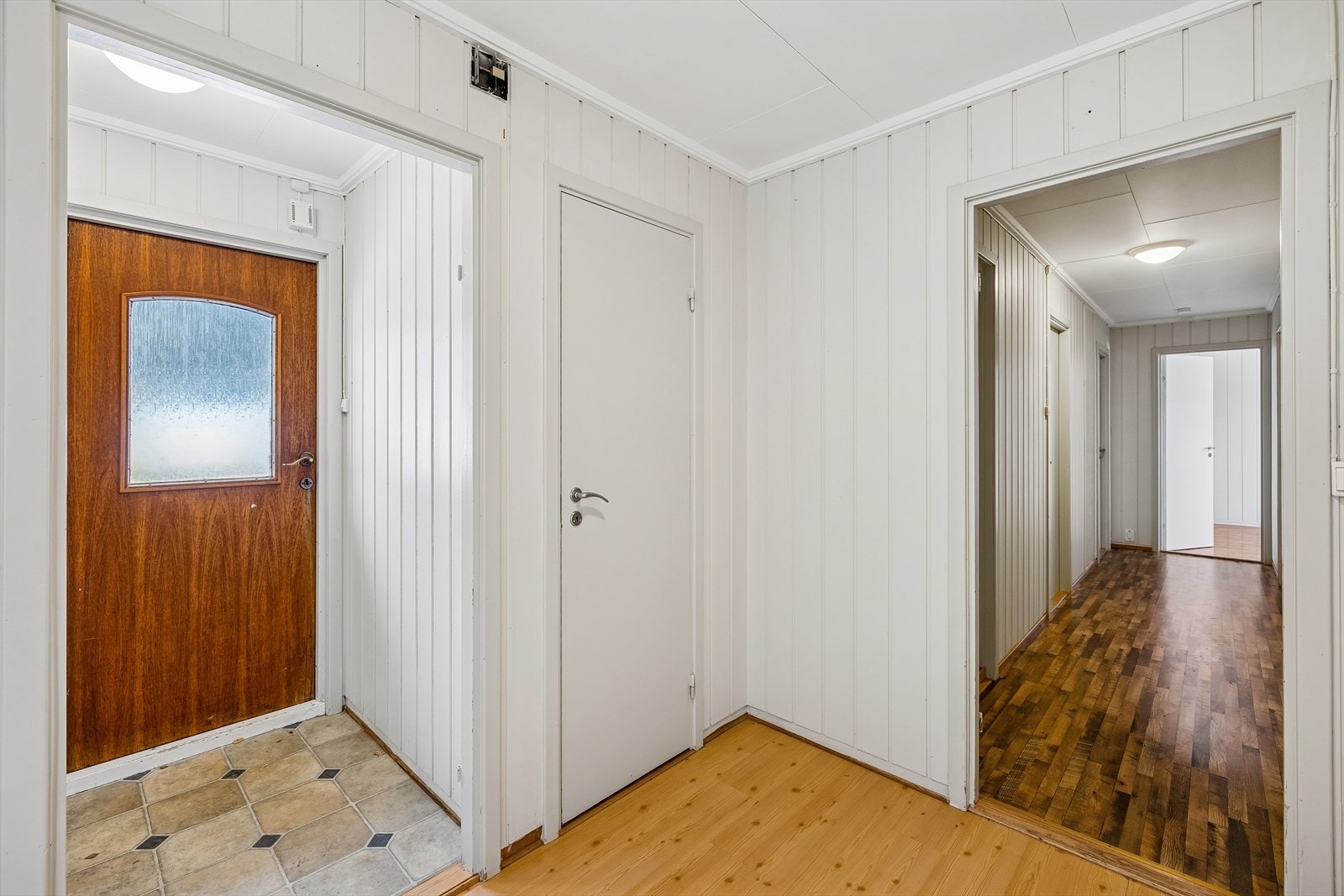 Entréen fungerer som et knutepunkt med tilgang til boligens sosiale soner og soveromsavdeling. Galleribilde