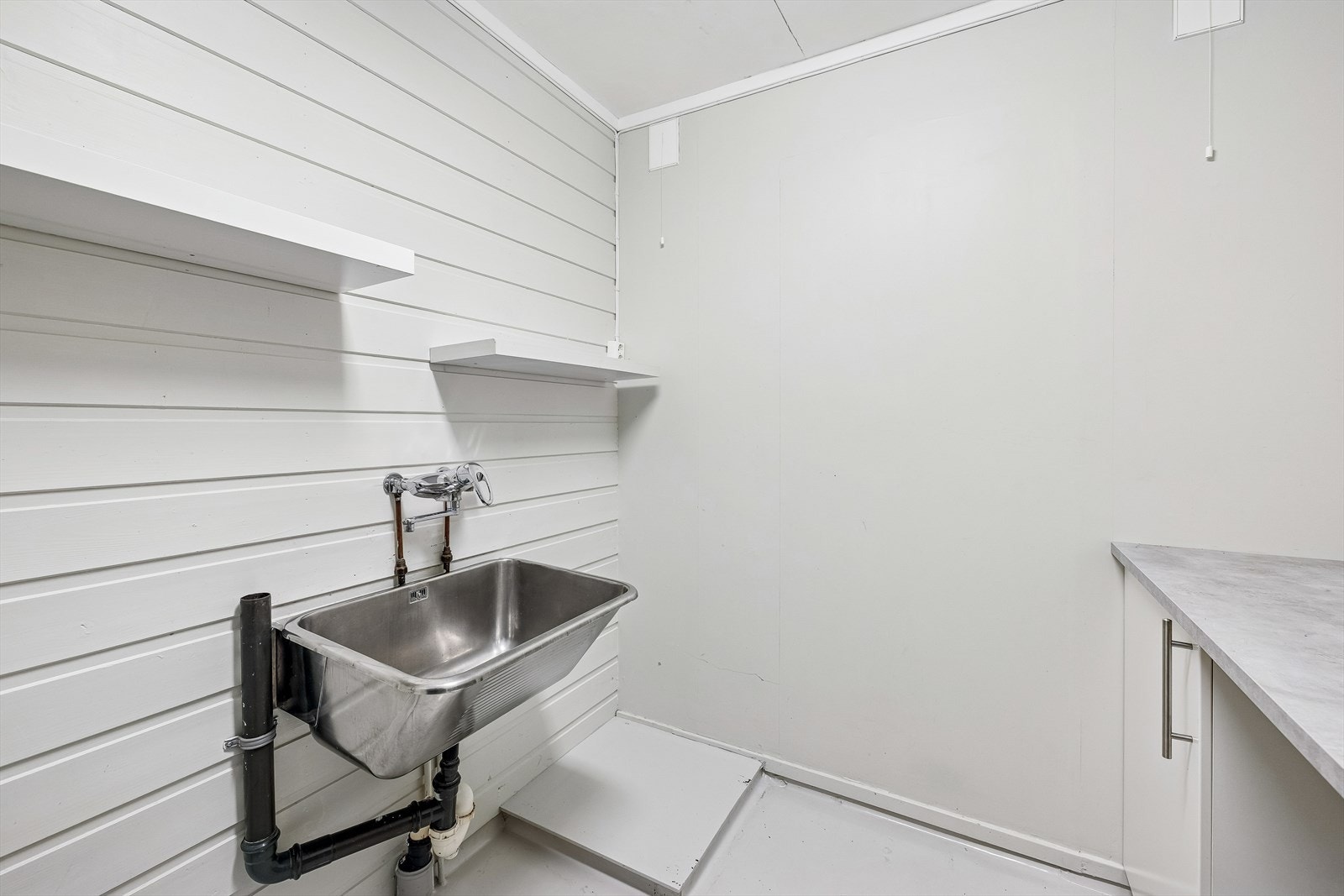 Eget vaskerom med utslagsvask og opplegg for vaskemaskin. Galleribilde