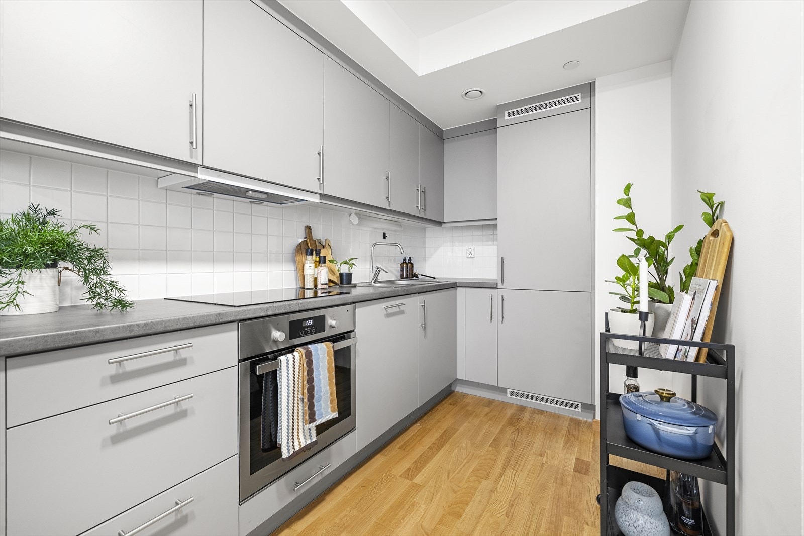 Kjøkkenet er innredet med glatte fronter og benkeplate av laminat. Det er integrerte hvitevarer som xx Galleribilde