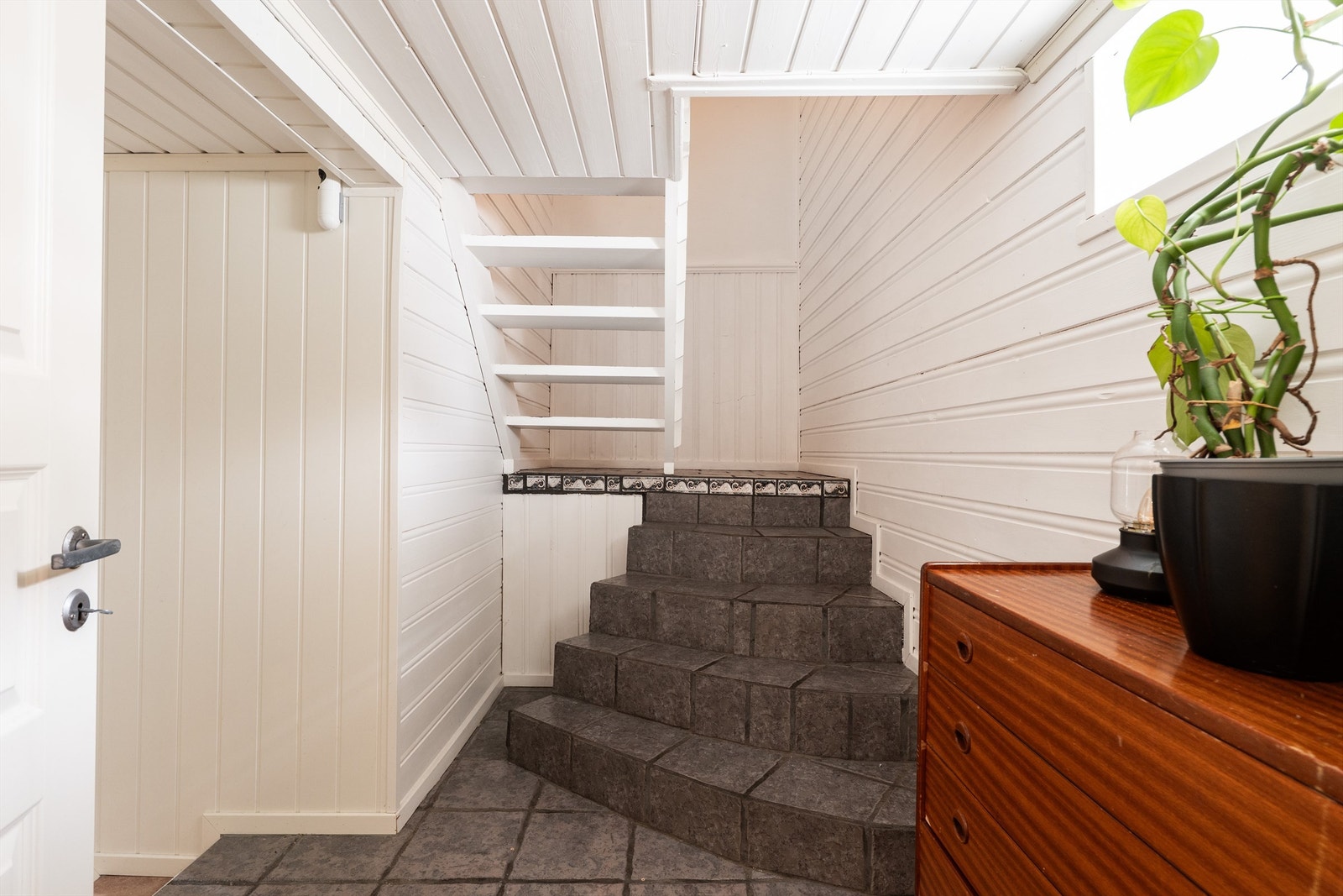 Mellomgang innenfor kjøkkenet, med trapp til andre etasje. Etasjens bad er også tilgjengelig fra denne gangen. Galleribilde