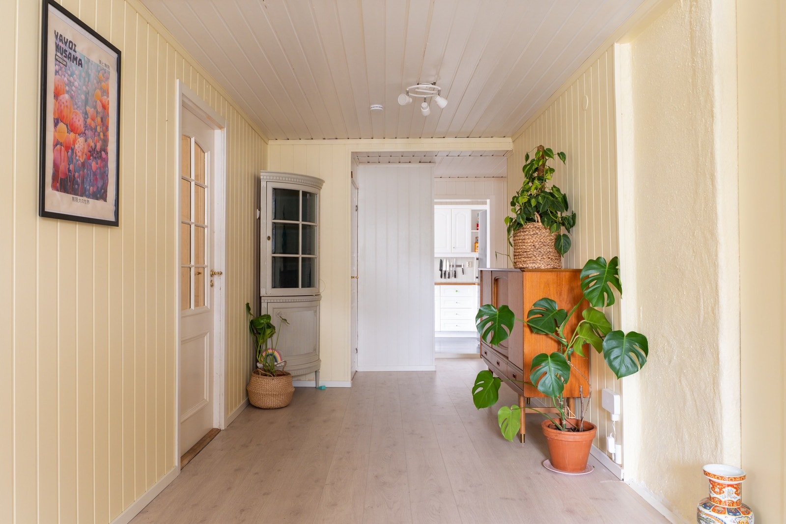 Det nye laminatgulvet er lagt gjennomgående til gangen, bindelettet mellom stuen og kjøkkenet. Galleribilde