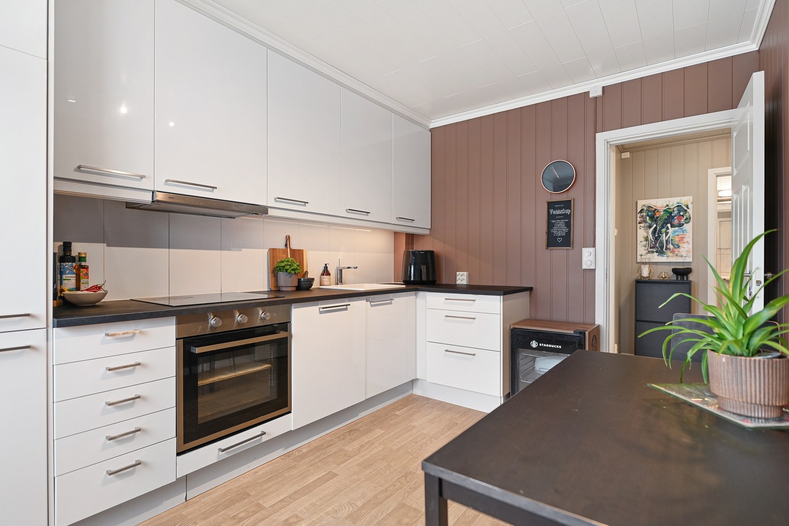 Kjøkkenet fremstår lyst og moderne med Ikea-innredning i hvit høyglans og integrerte hvitevarer. Galleribilde