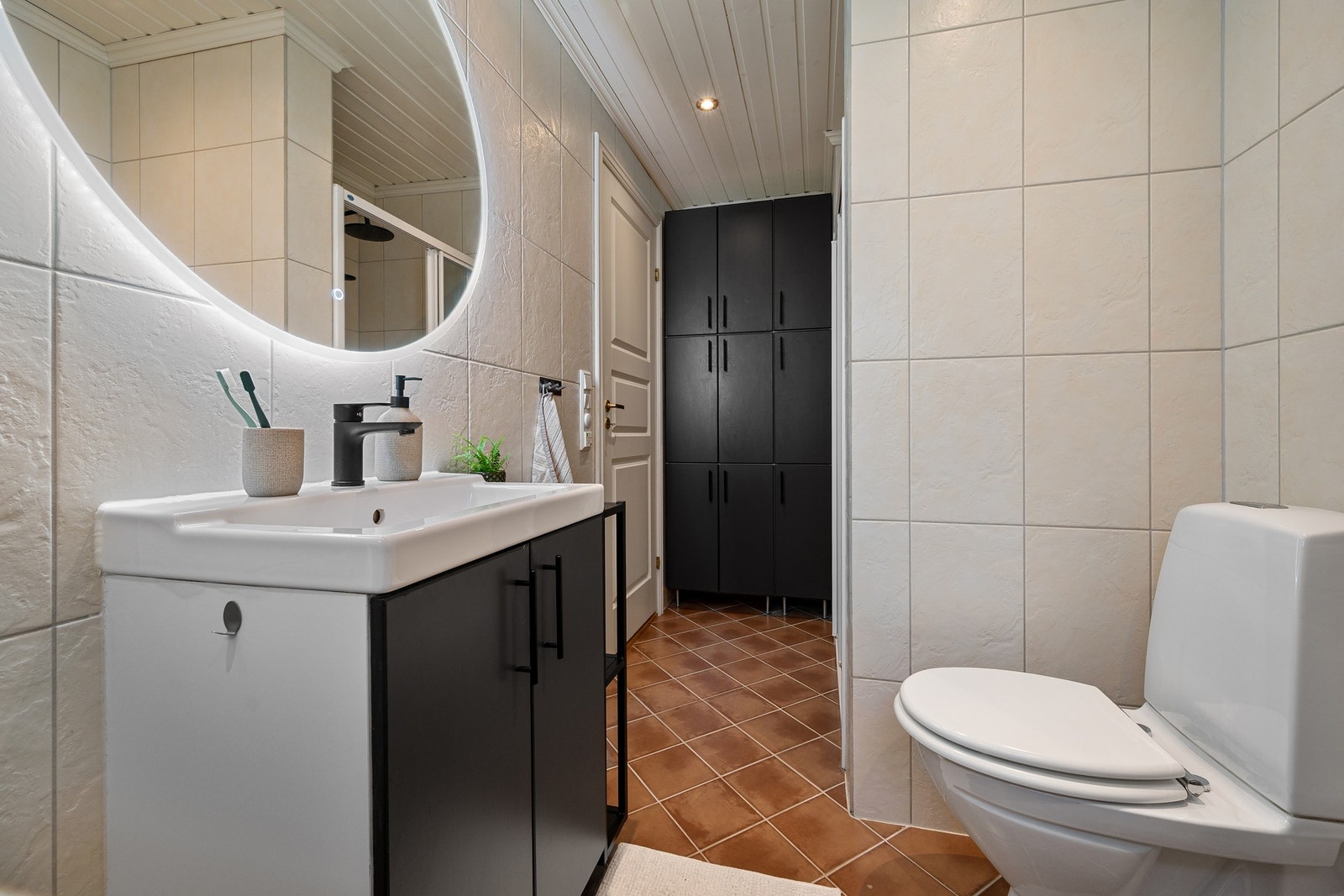 Gode oppbevaringsmuligheter på baderommet med skap ved dusjsone og skap under servant. Galleribilde