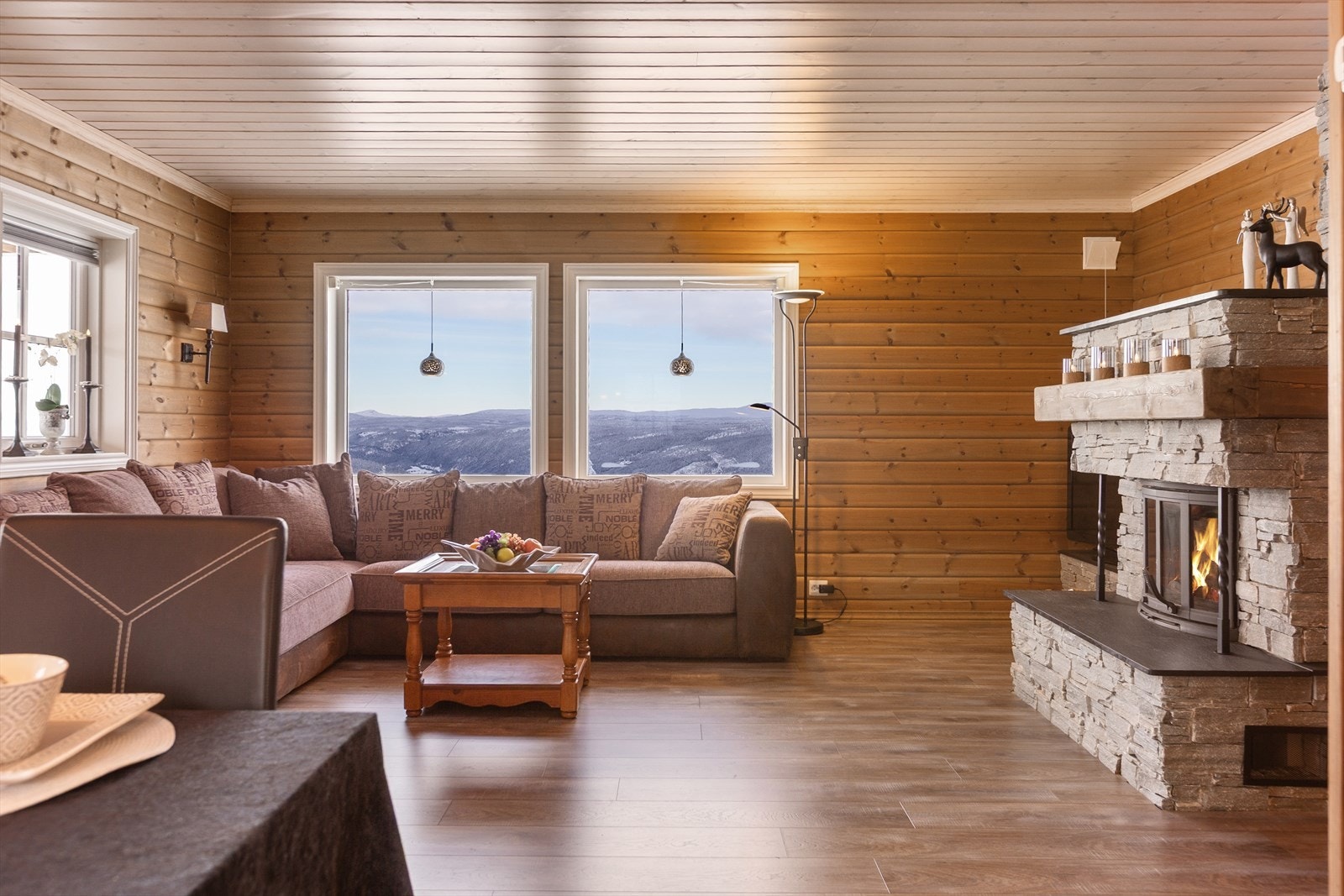 En vakker peis forblendet med fasadeskifer, trestokk på peisbru og skifer på bunn og topp, gir ekstra varme på friske dager. Galleribilde