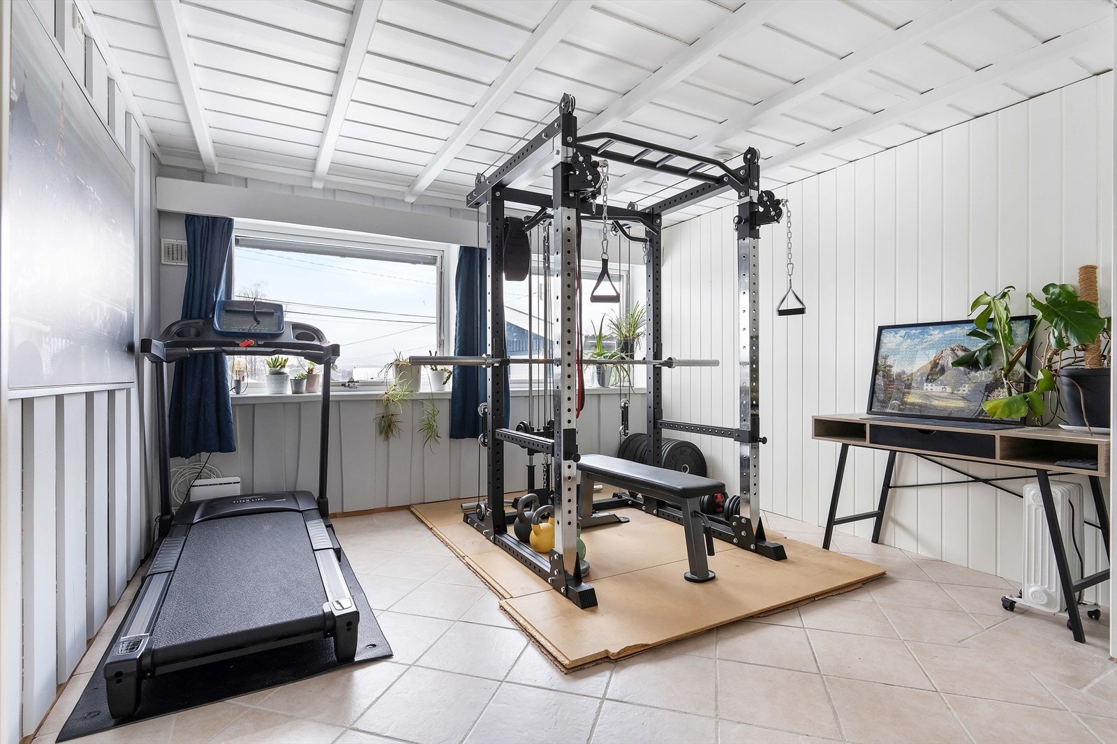 Det største soverommet i underetasjen er idag innredet med ulike treningsapparater. Dette rommet kan fint benyttes som kontor eller TV-stue om man ikke har behov for et fjerde soverom. Galleribilde