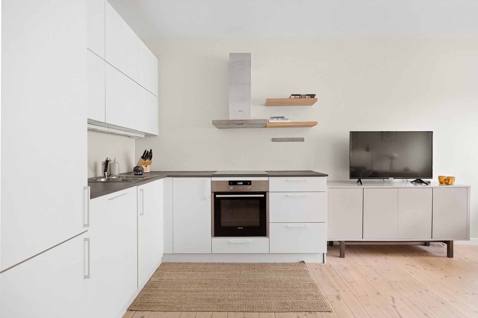 Integrerte hvitevarer som platetopp med induksjon, stekeovn, oppvaskmaskin og kjøl-/fryseskap. Galleribilde