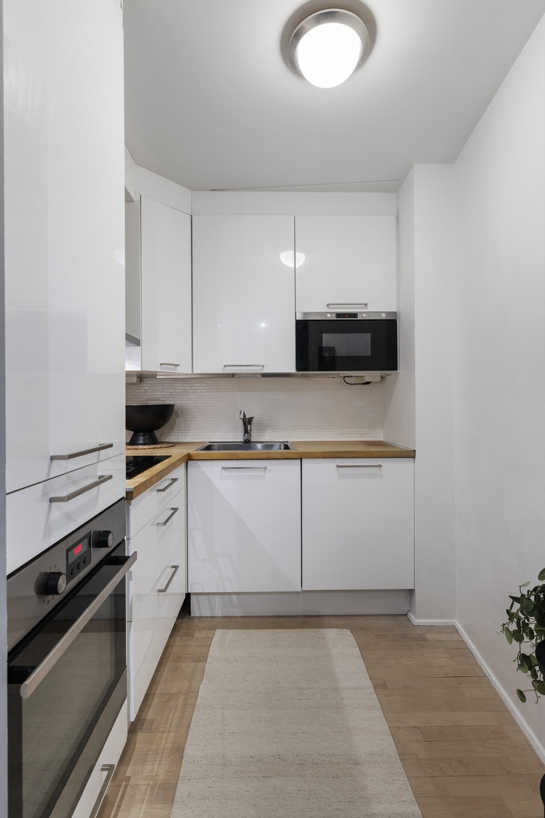 Kjøkkenet har åpen adkomst fra stuen. Lysmalte flater og parkett på gulv Galleribilde