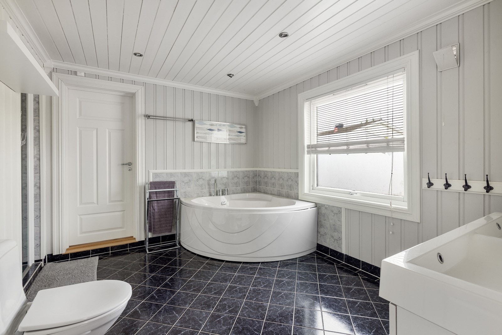 Boligen har et stort og lyst baderom som ble pusset opp i 2004. Baderommet har flislagt gulv med gulvvarme, overflater med fliser og malt panel, samt downlights i himlingen. Galleribilde