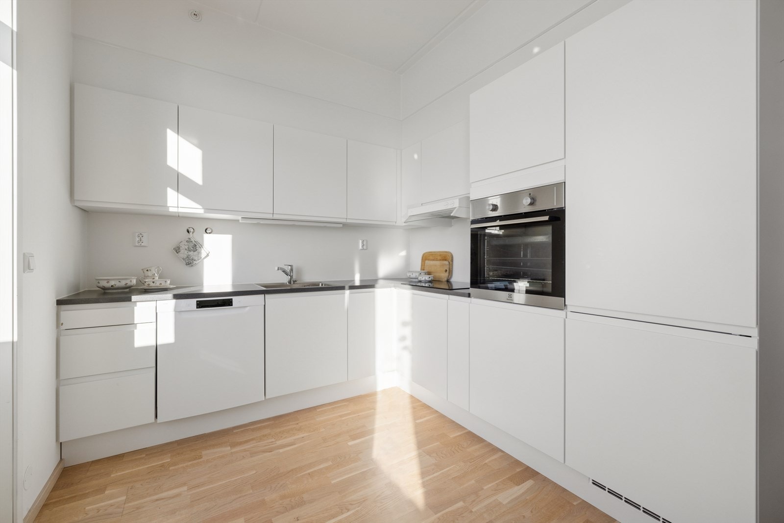 Lyst og moderne kjøkken som har rikelig med skap- og benkeplass. Galleribilde