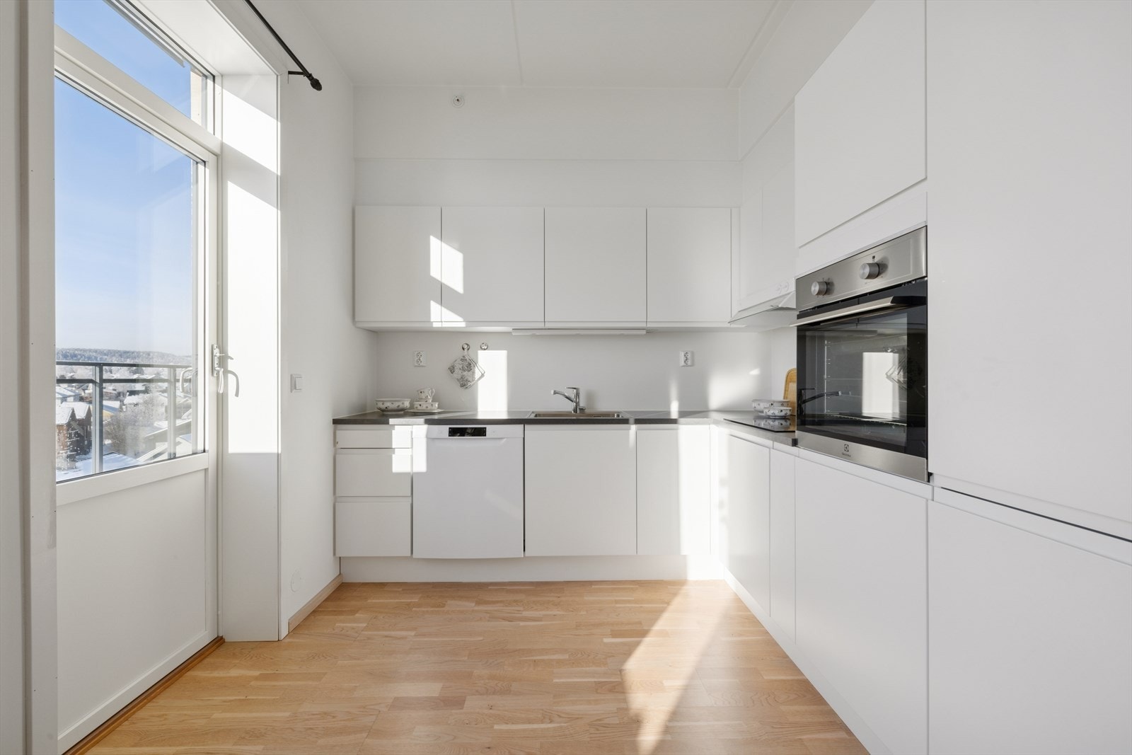 Kjøkkeninnredning med glatte fronter og laminert benkeplate. Utgang til balkong på ca. 8,4 kvm. Galleribilde