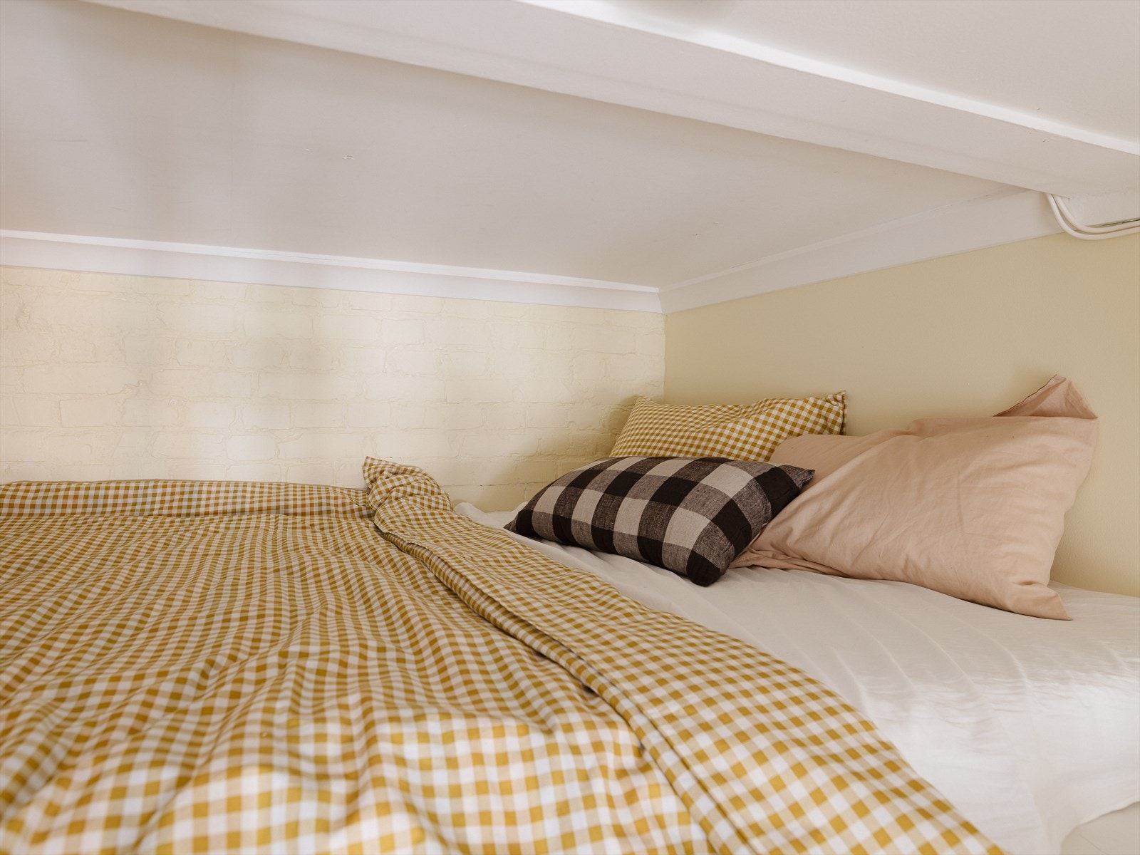 Fra soverommet er det en trappestige opp til hems. Her er det i dag innredet en seng til gjester. Galleribilde