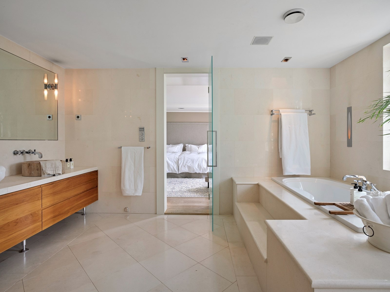 Lekkert flislagt bad med badekar, marmor benk og downlights i himling. Galleribilde