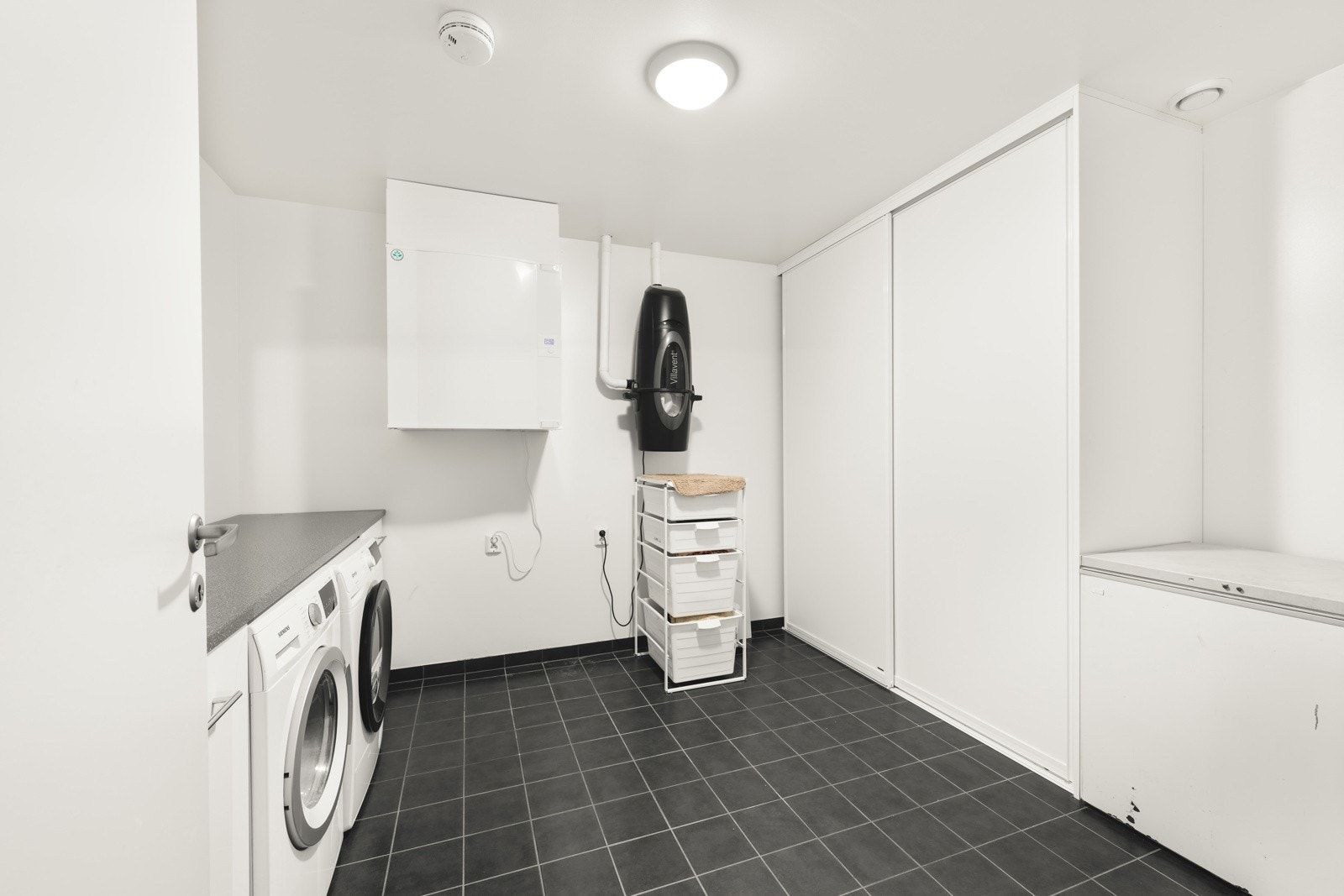 Vaskerom/teknisk rom med flislagt gulv med varme som gir en lun og praktisk løsning. Galleribilde