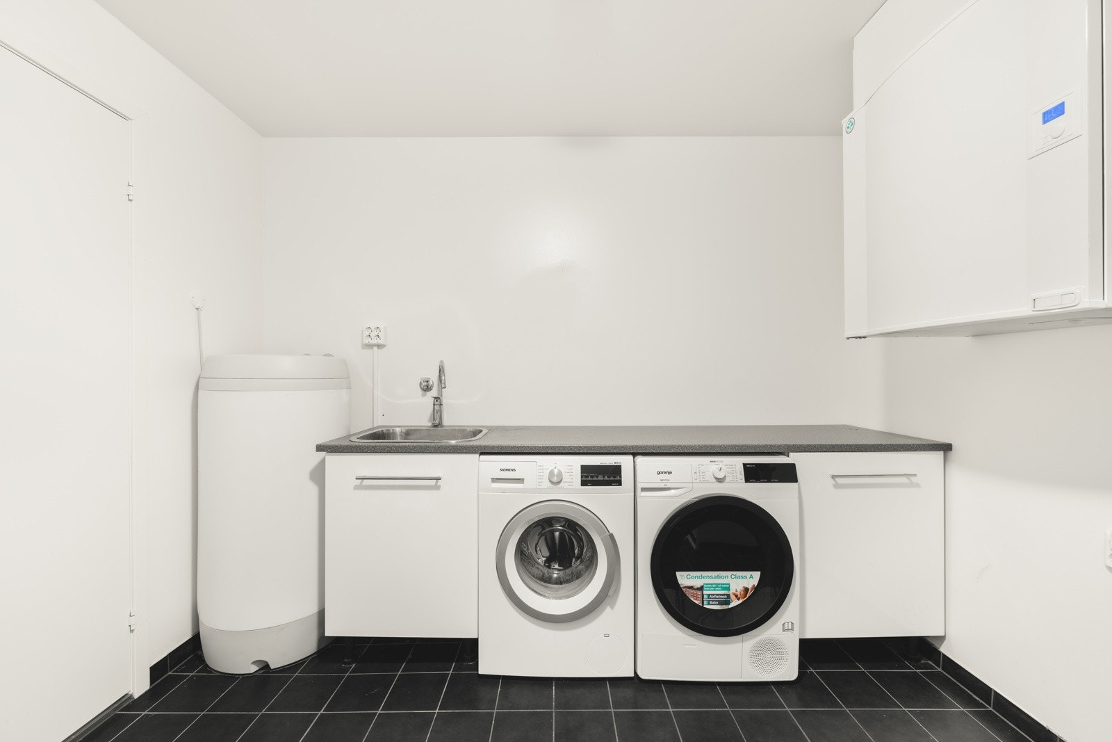 Rommet er utstyrt med innredning med vask samt plass til både vaskemaskin og tørketrommel. En funksjonell og ryddig sone som gjør hverdagen enklere. Galleribilde