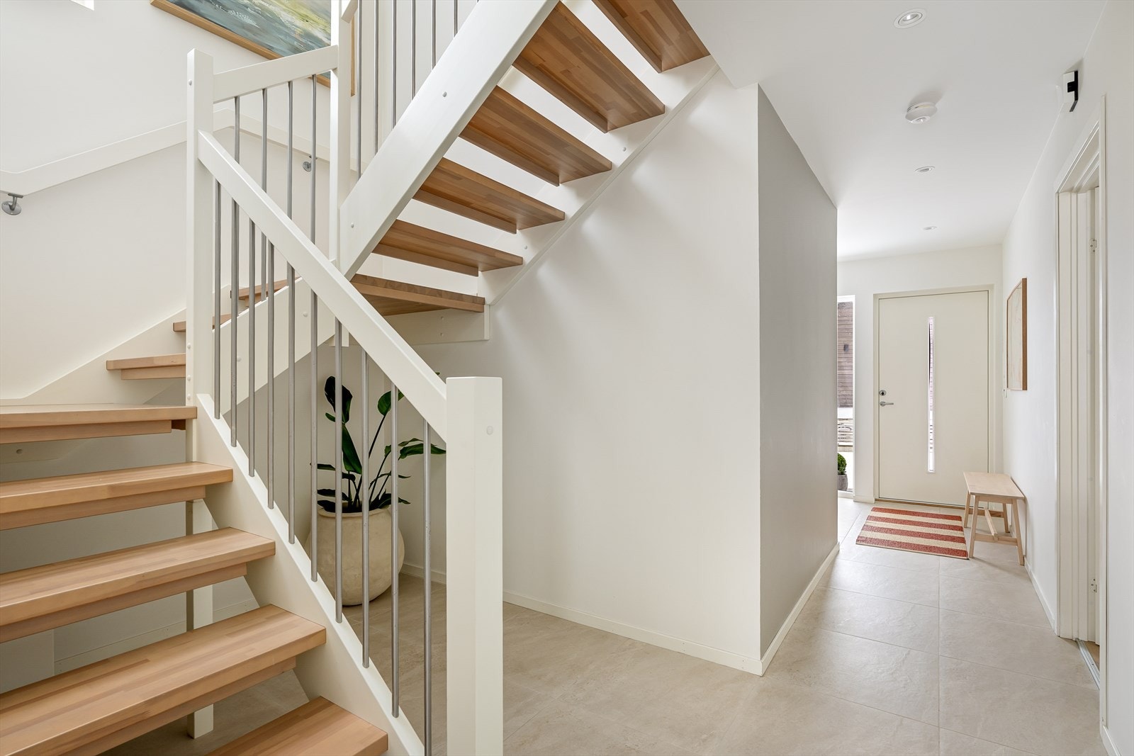 En malt og lakkert tretrapp leder videre opp til 2. etasje. Galleribilde