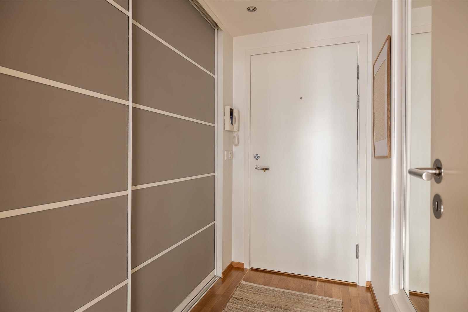 Innbydende entré med stor skyvedørsgarderobe Galleribilde