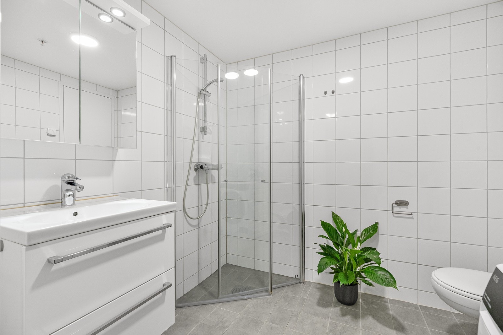 Stilrent bad/vaskerom med fliser på gulv og vegger Galleribilde