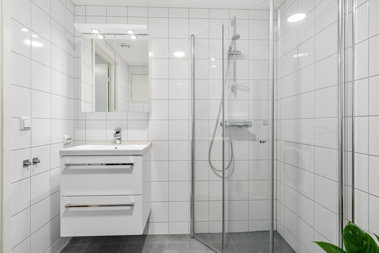 Rommet har innredning med nedfelt servant, veggmontert toalett, dusjvegger/hjørne. Det er tilrettelagt for vaskemaskin, og vannbåren gulvvarme sørger for god komfort. Galleribilde