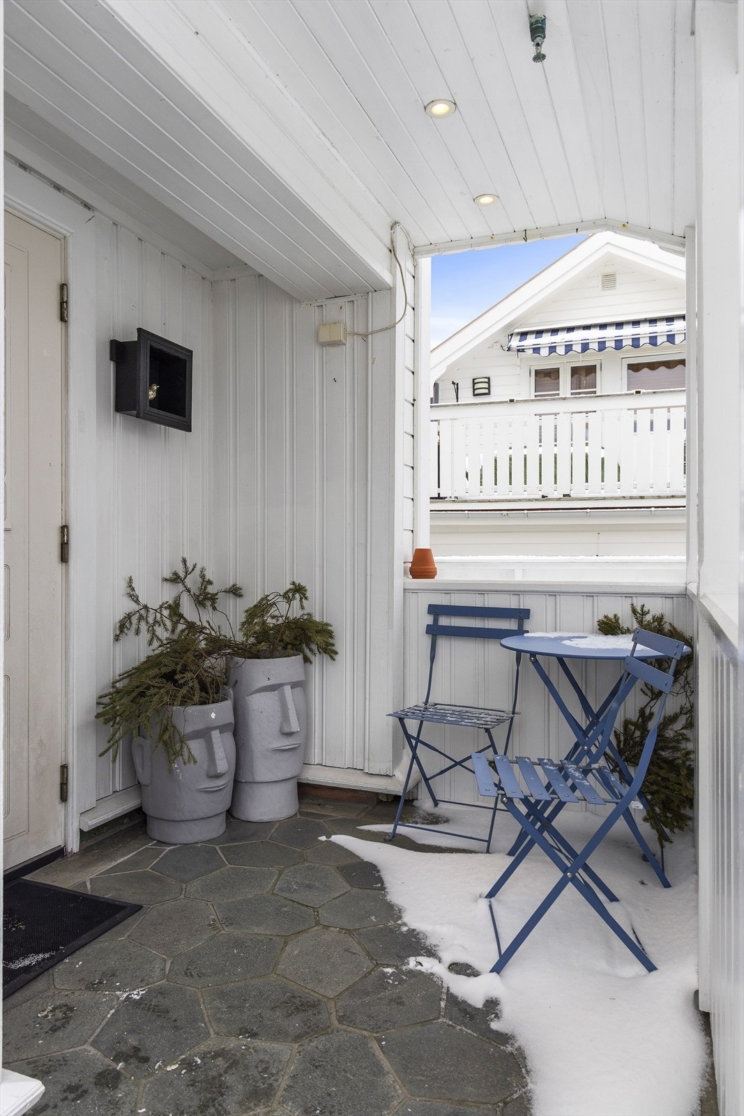 Inngangsparti bygget med skifer og smijernsrekkverk. Spotter i himling. Galleribilde