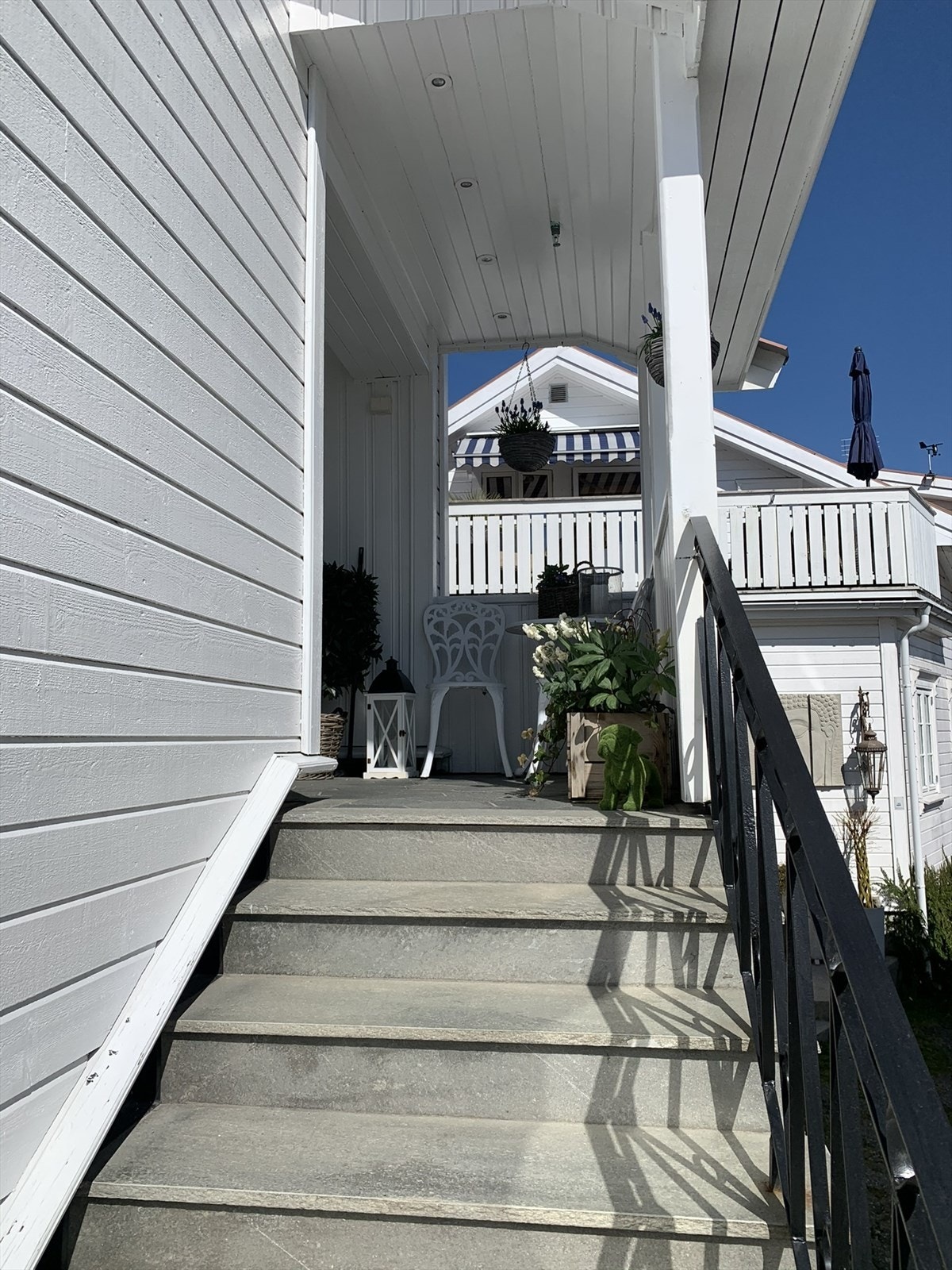 Overbygget inngangsparti med plass til liten sittegruppe. Selgers bilde. Galleribilde