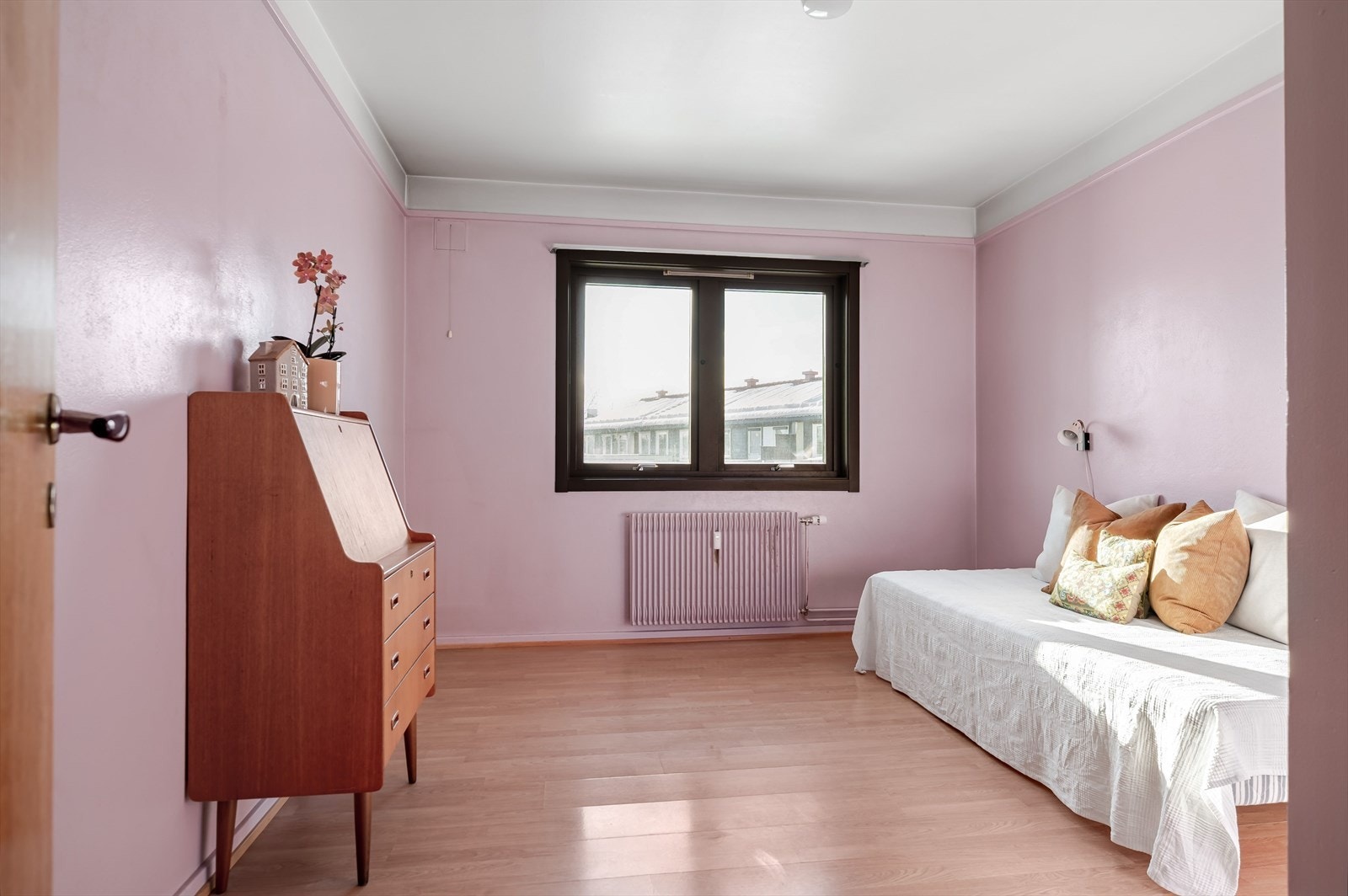 Soverom 1 er et stort soverom med laminat på gulv og overflater malt i en fin rosafarge. Galleribilde