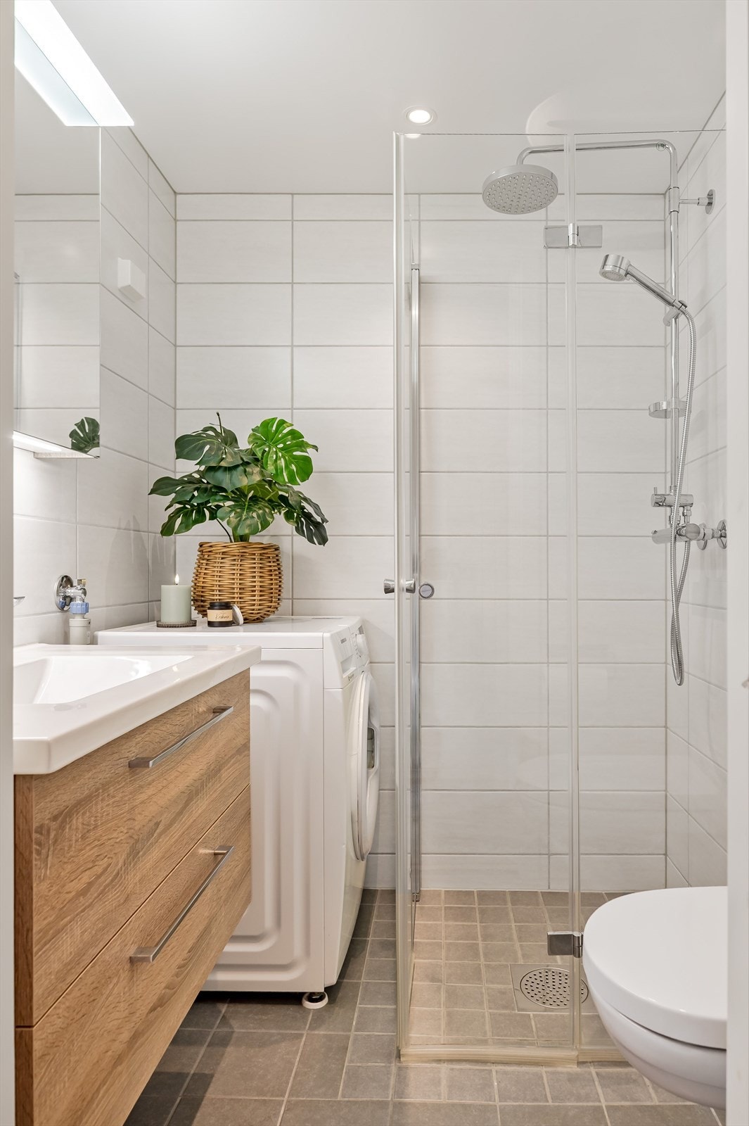 Leiligheten har et lyst og moderne baderom som ble pusset opp i regi av brl. i 2020. Baderommet har grå fliser på gulv, elektrisk gulvvarme, lyse fliser på veggene, downlights i himlingen og avtrekk tilknyttet sentralt ventilasjonsanlegg for blokka. Galleribilde