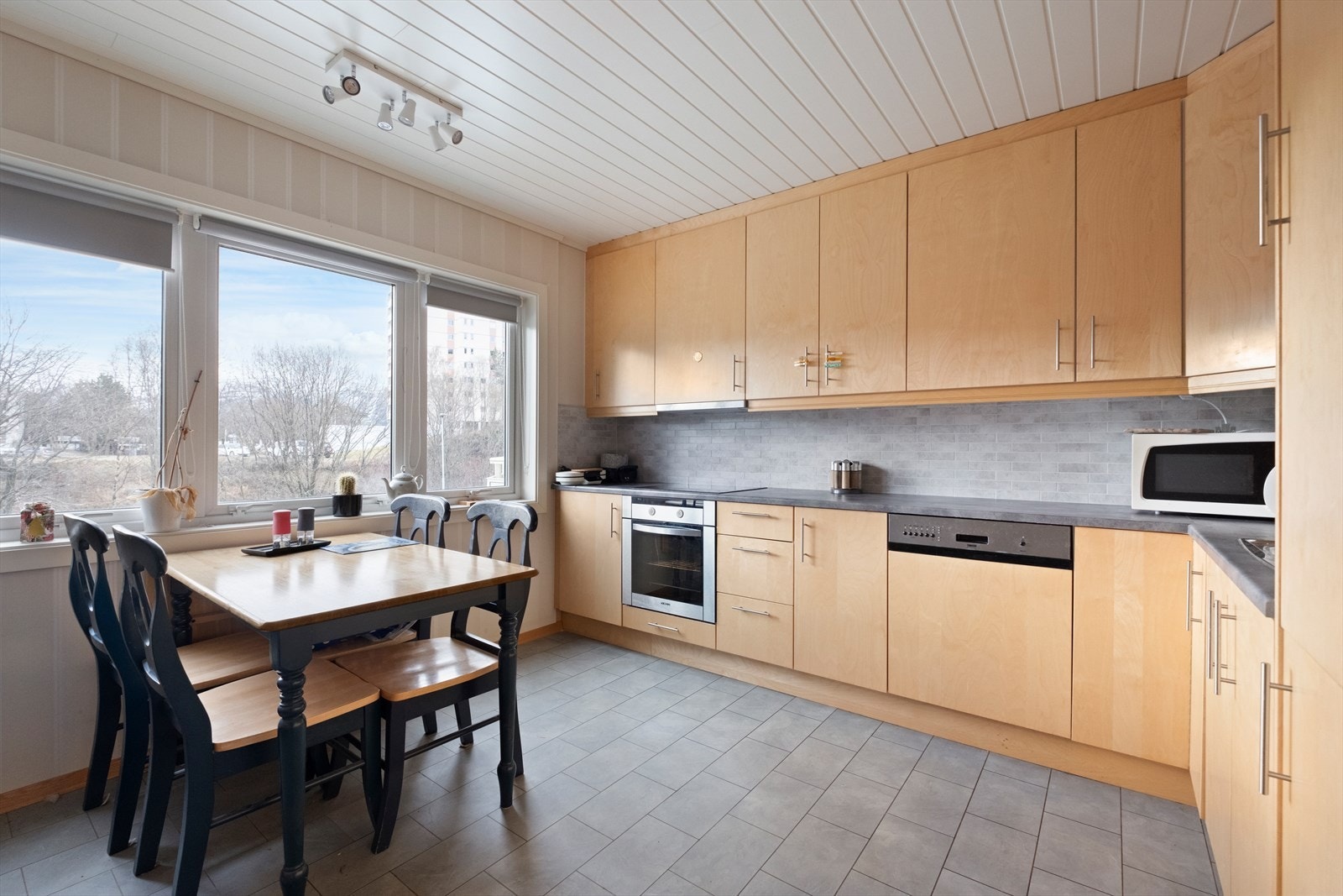 Pent og tidløst kjøkken med integrerte hvitevarer. Mye skap- og benkplass. Galleribilde