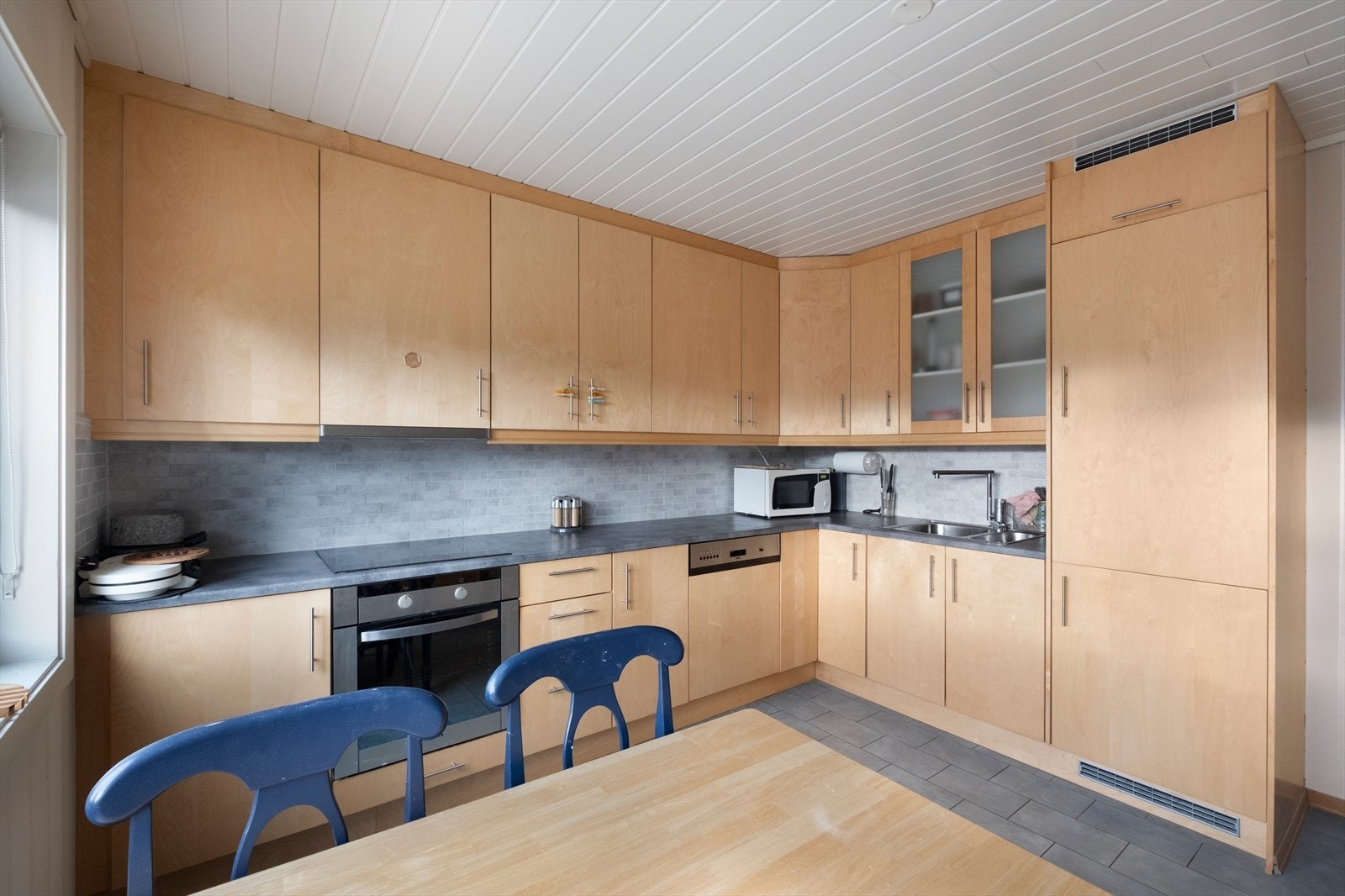 Pent og tidløst kjøkken med integrerte hvitevarer. Mye skap- og benkplass. Galleribilde