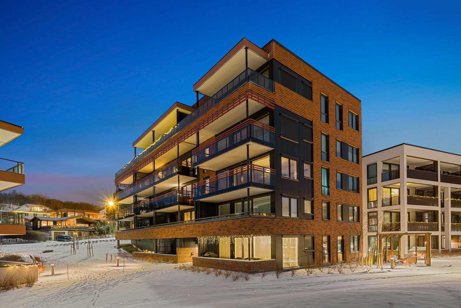 Fasadebilde. Området er pent opparbeidet med grøntområder, lekeplasser og internveier. Galleribilde