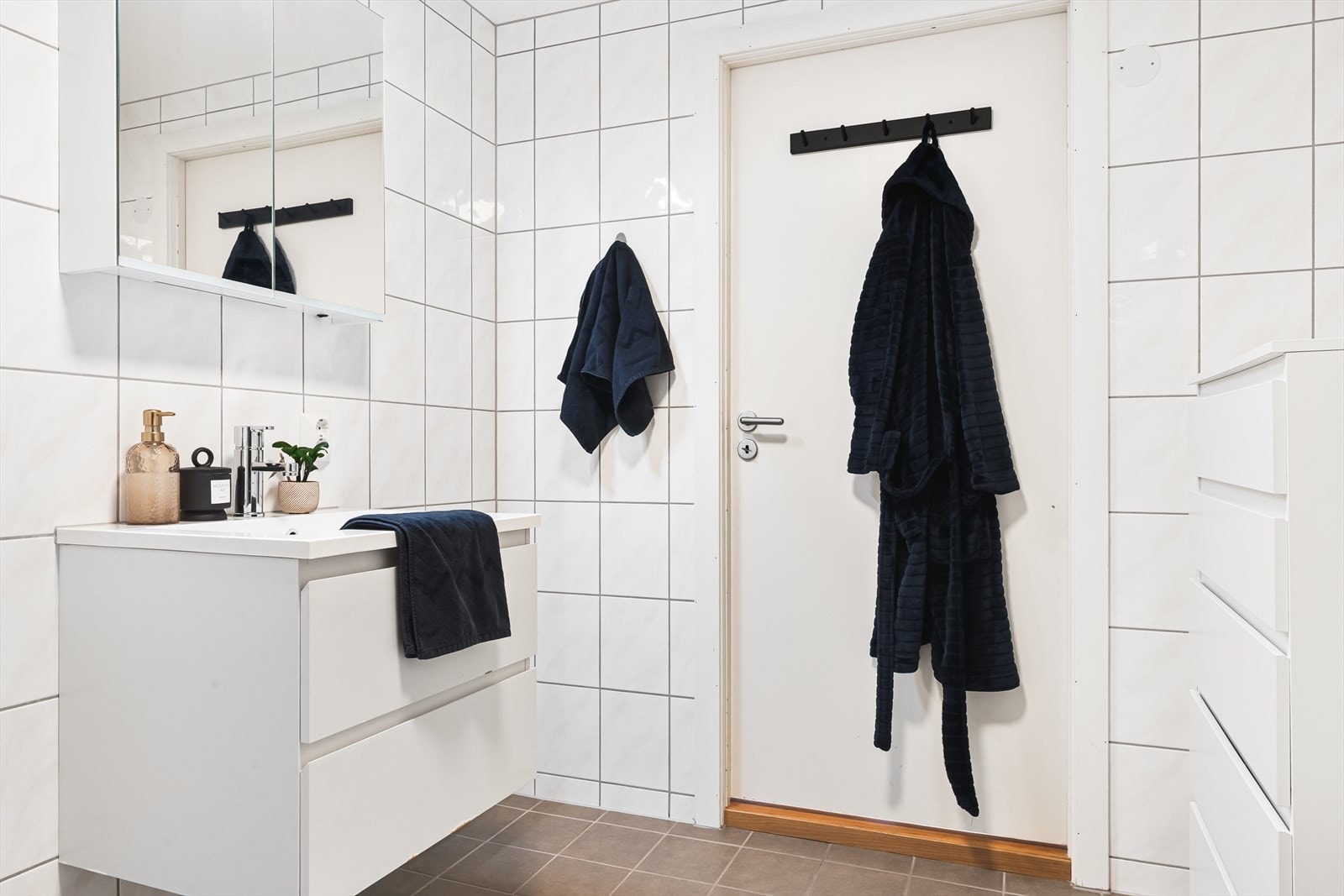 Badet har innredning med nedfelt servant, veggmontert toalett, dusjvegger/hjørne og opplegg for vaskemaskin. Det er balansert ventilasjon med tilluft under dørblad. Galleribilde